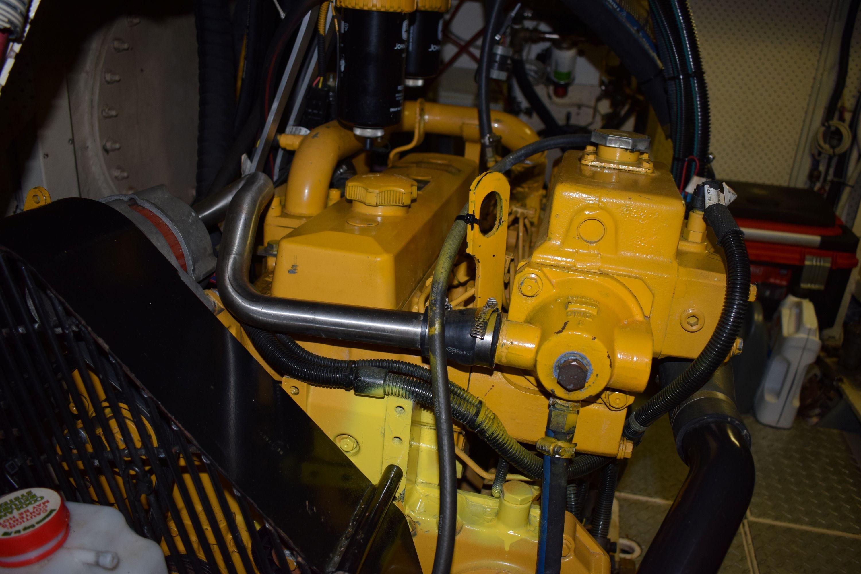 Engine room of 1980 Cheoy Lee 52 Motorsailer with yellow machinery components.