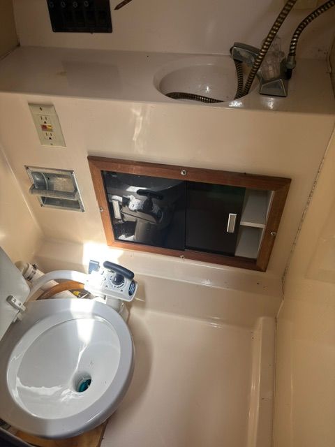 Interior of a boat bathroom with sink, mirror, and fixtures.