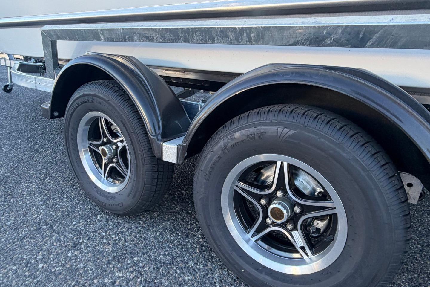 Trailer wheels of a 2026 Thunder Jet 209 Rush OT boat on asphalt.