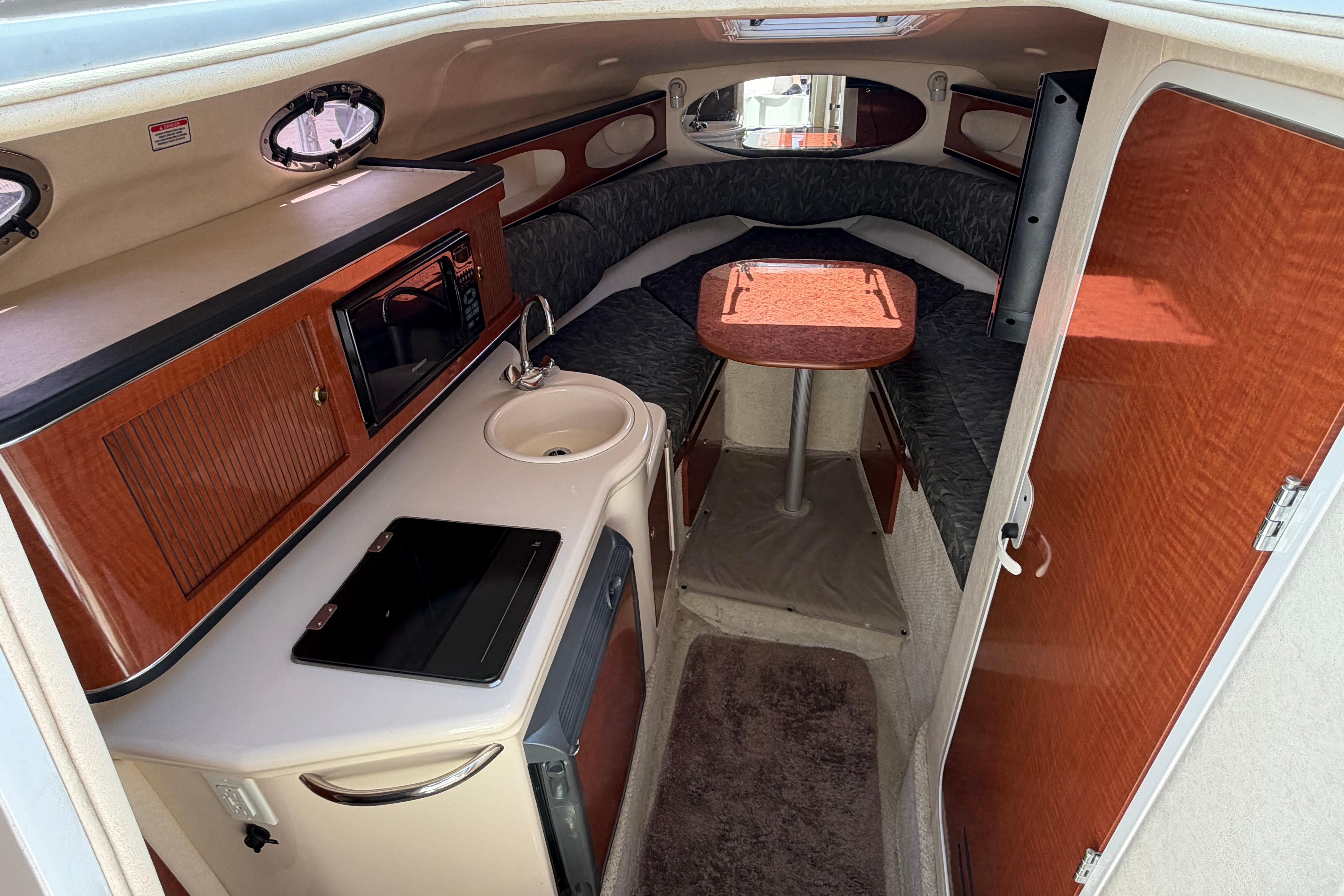 Interior of 2004 Sea Ray Sundancer 260 boat with kitchenette and seating area.