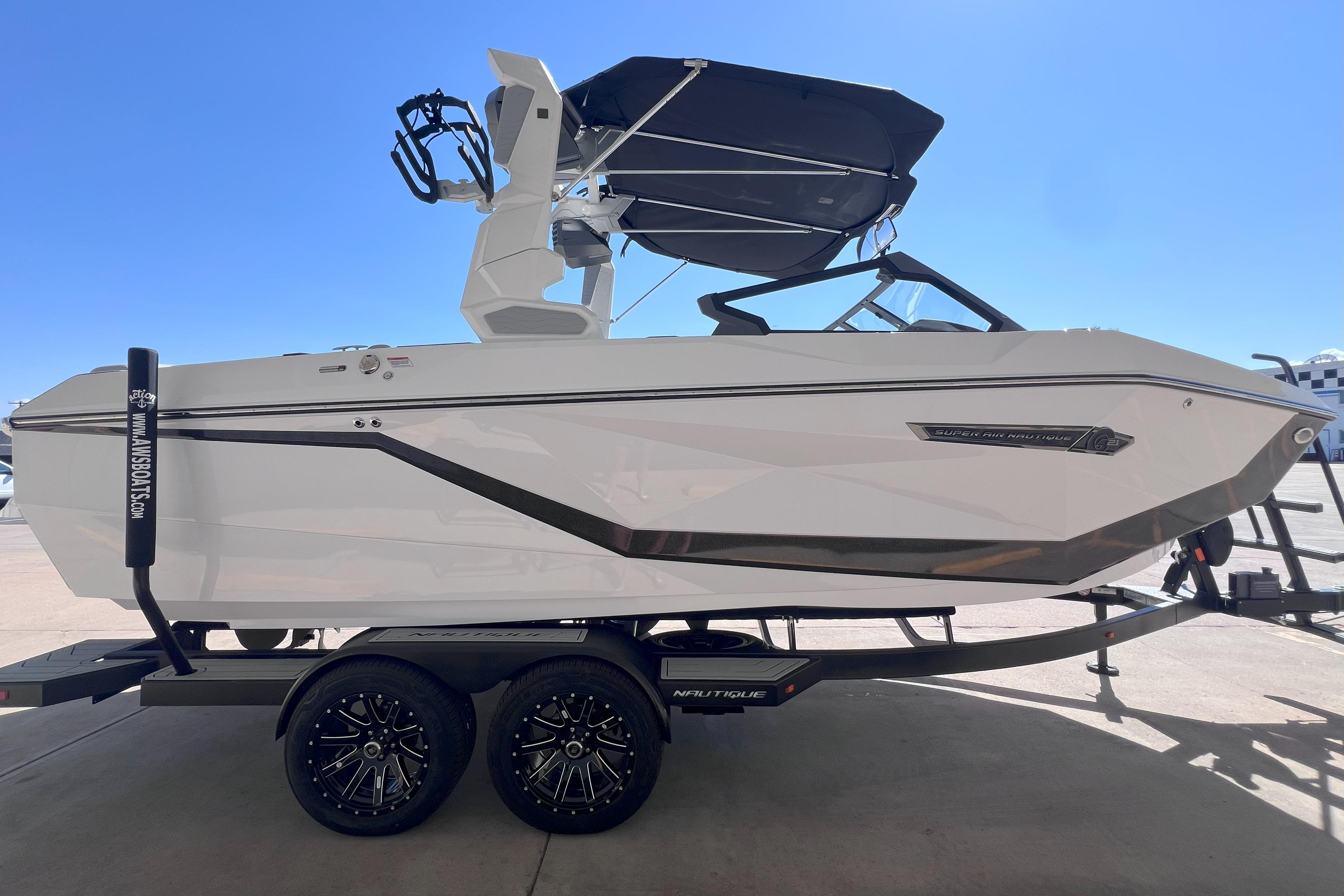 2025 Nautique Super Air Nautique G21 boat on trailer, side view, sunny day.