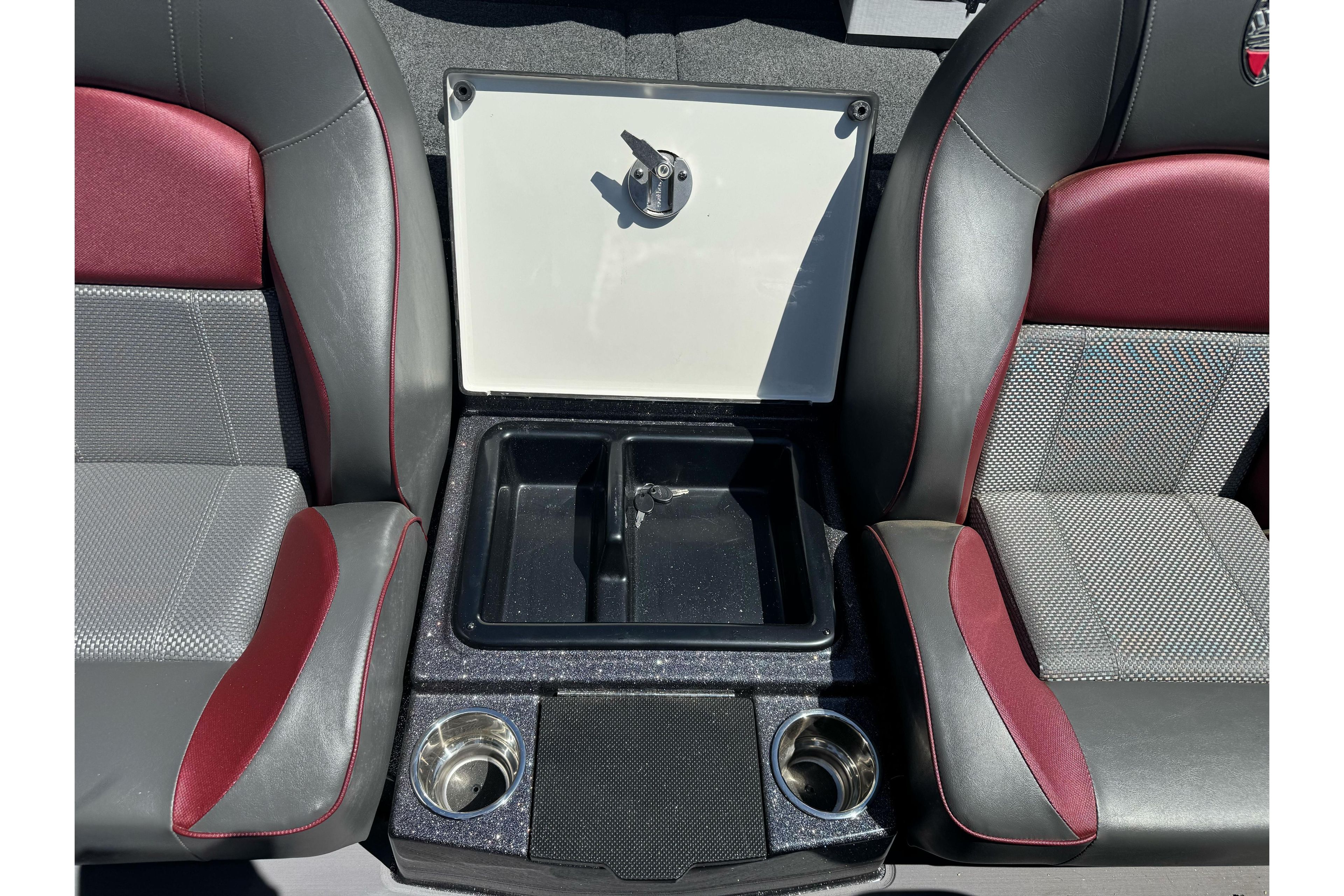 Interior of 2026 Triton 18 TrX boat with storage compartment and cup holders.