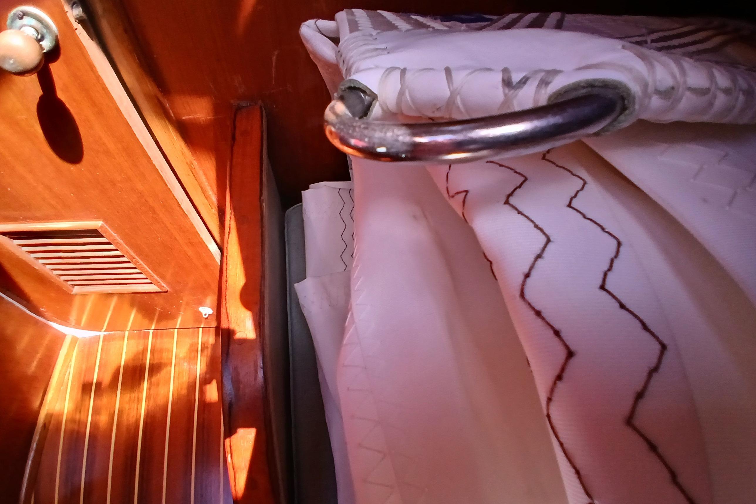 Interior of 1981 Kaufman Skye 51 yacht with wooden paneling and patterned fabric.