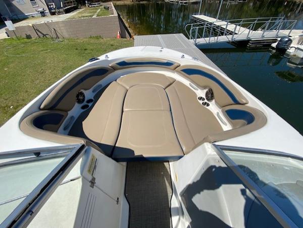 2005 Bayliner 249 SD boat interior with tan seating and cup holders, docked by the water.