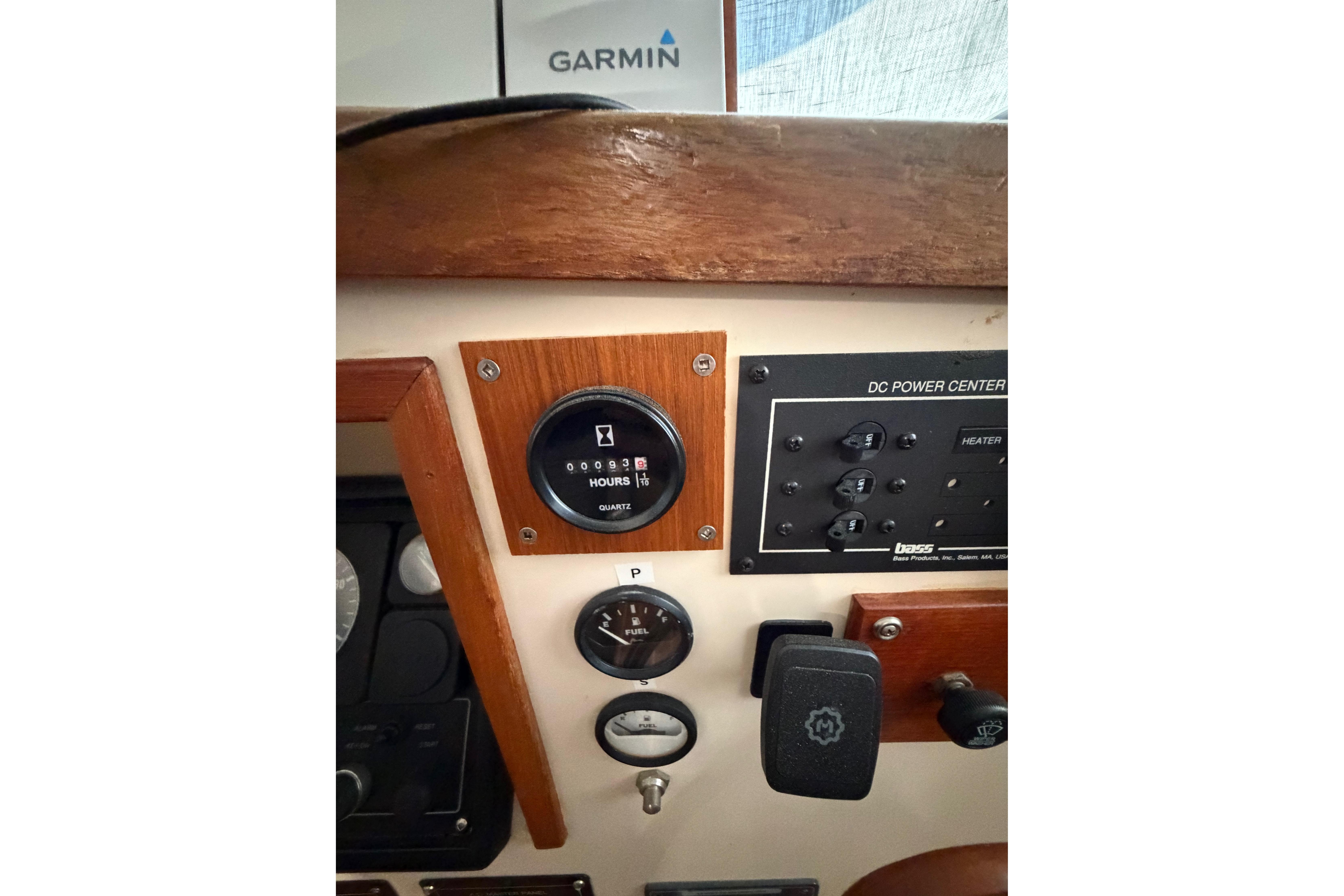 Control panel of a 1997 Rosborough Trawler featuring gauges and a Garmin device.