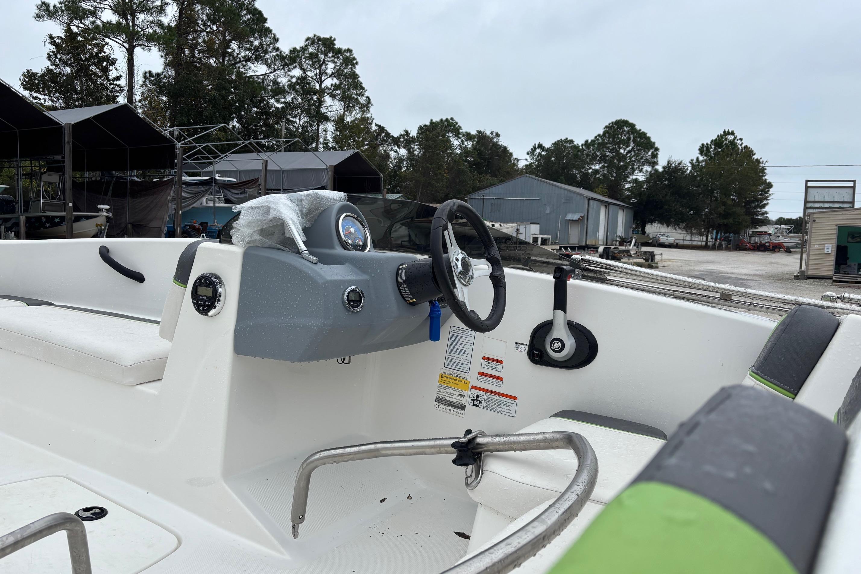 2022 Tahoe T16 boat interior with steering wheel and seating, parked outdoors.