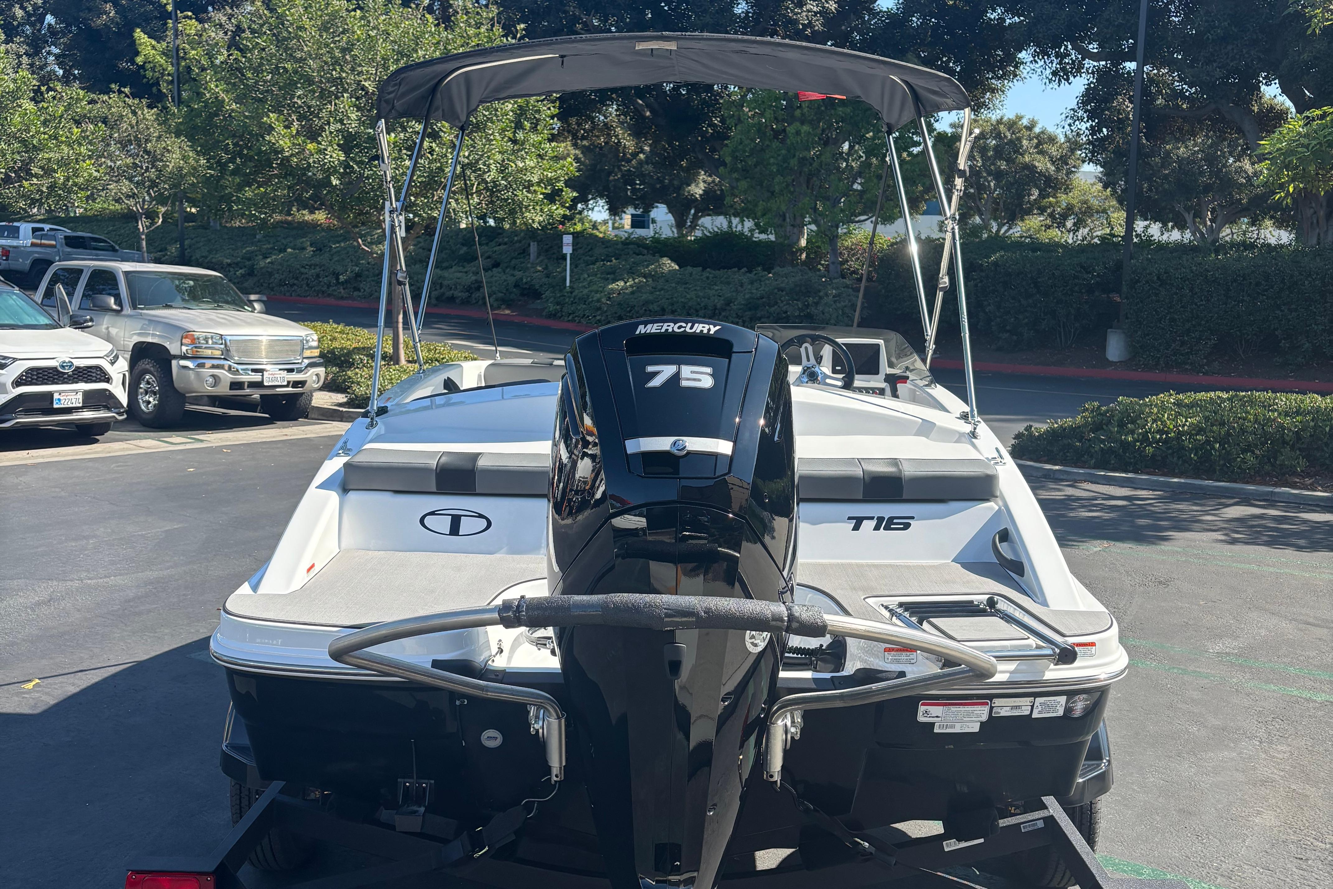 2026 Tahoe T16 boat with Mercury 75 engine in a parking lot.