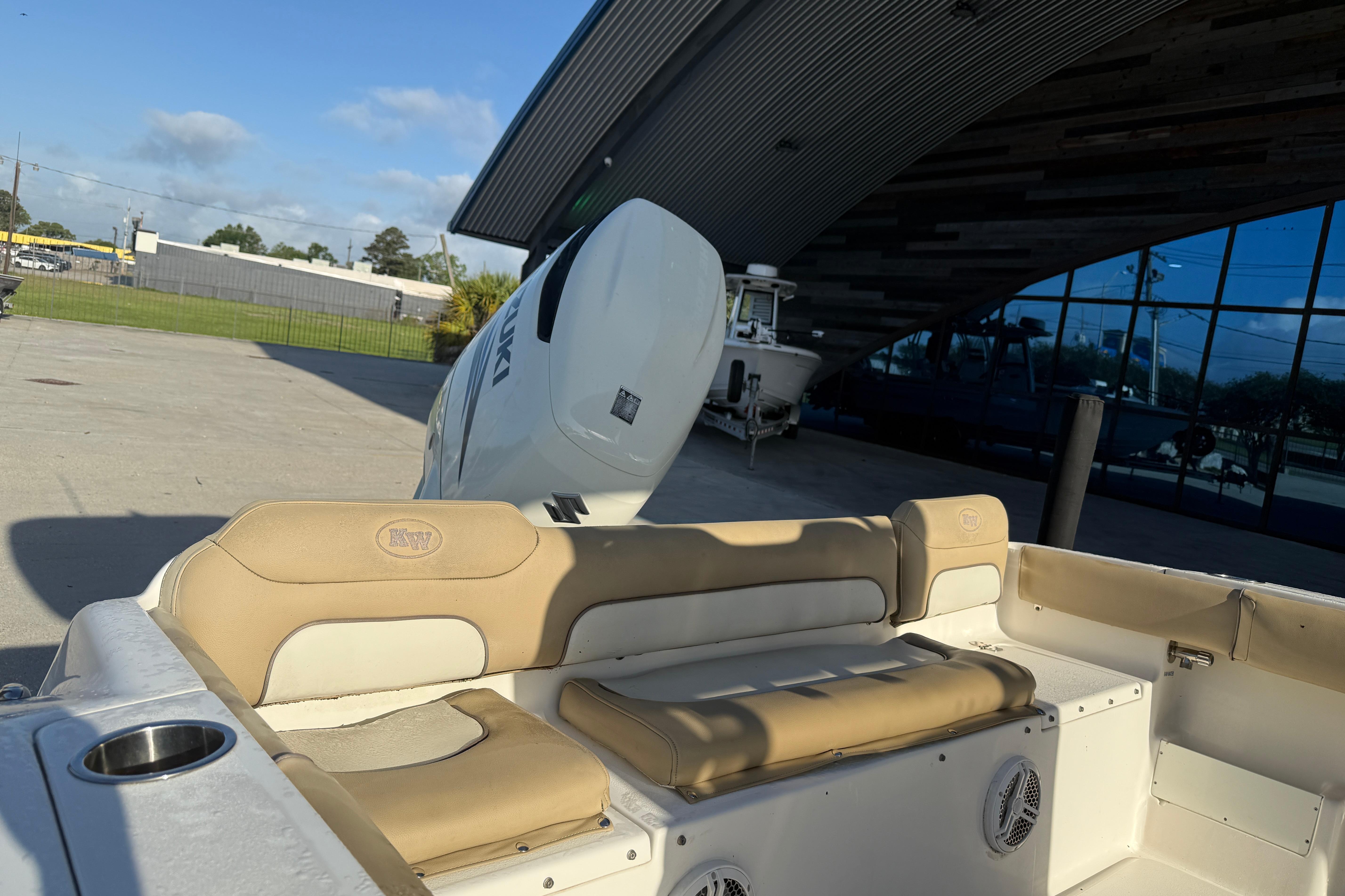2016 Key West 239 FS boat with Suzuki outboard motor, parked near a modern building.