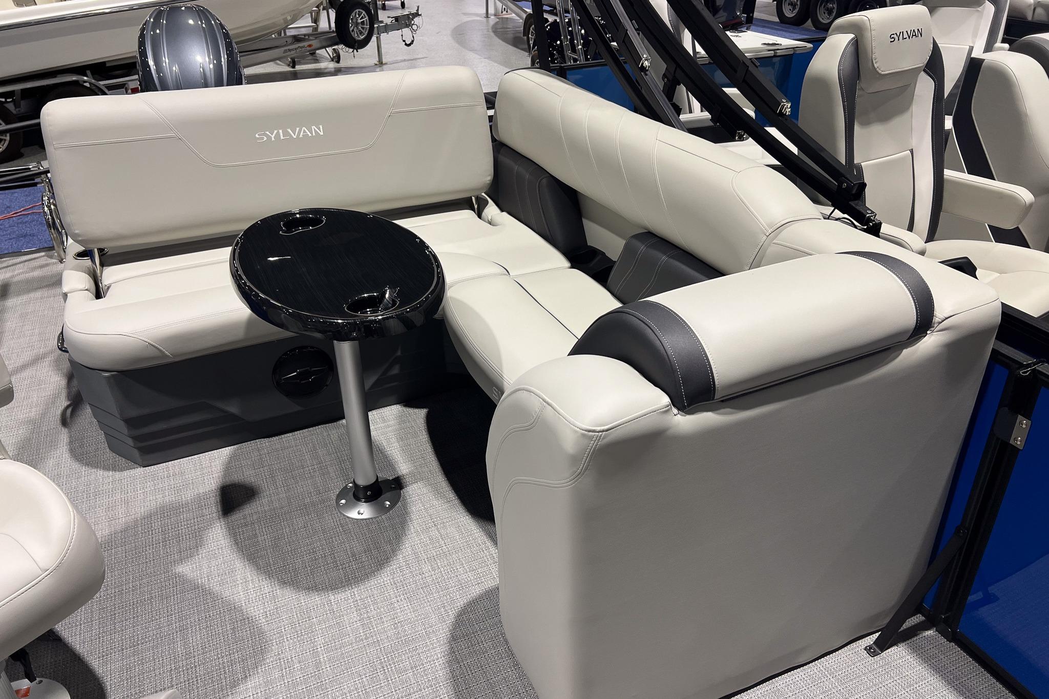 2026 Sylvan Mirage 822 CLZ boat interior with plush seating and a sleek black table.