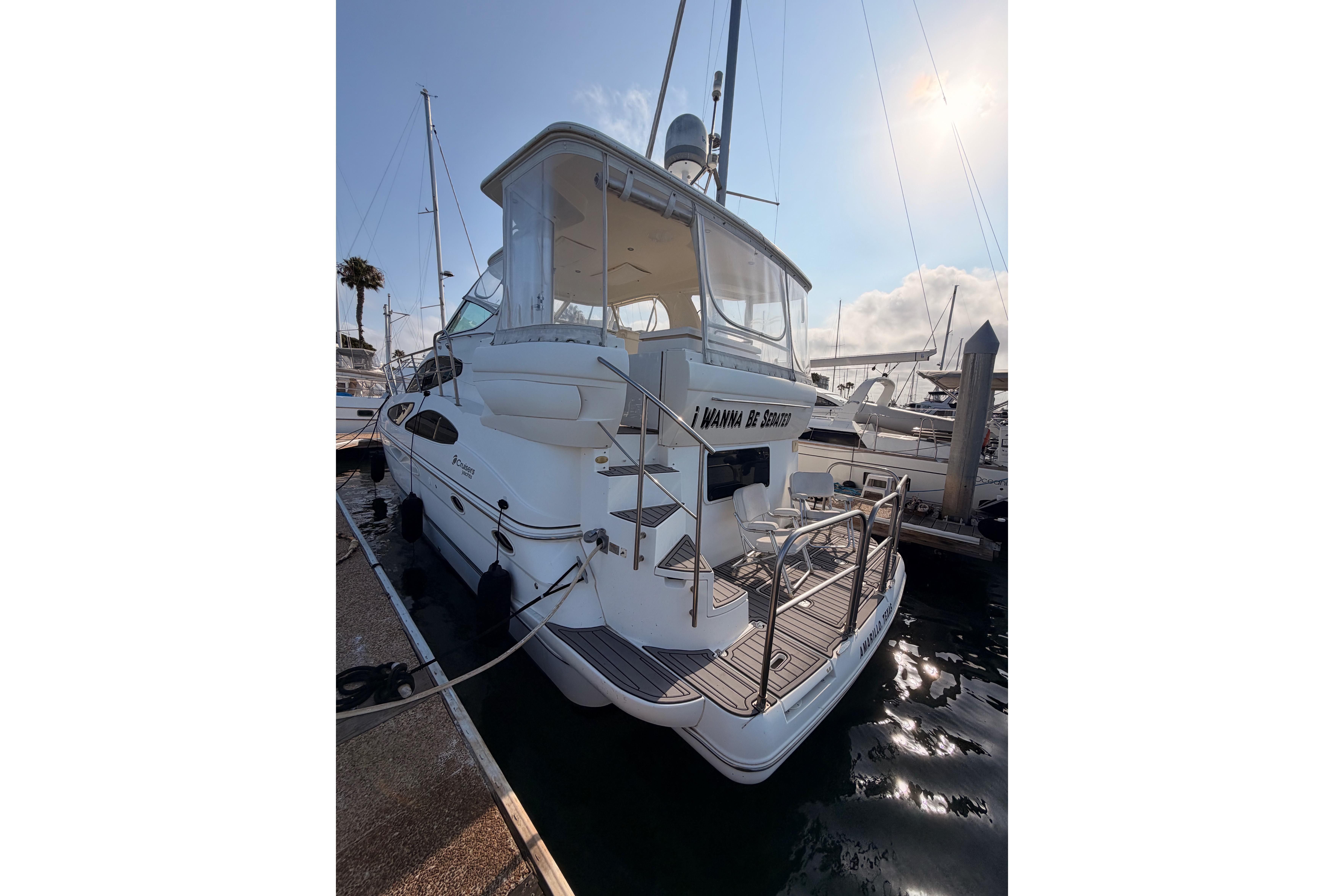 2005 Cruisers Yachts 405 Express Motoryacht docked at marina under sunny sky.
