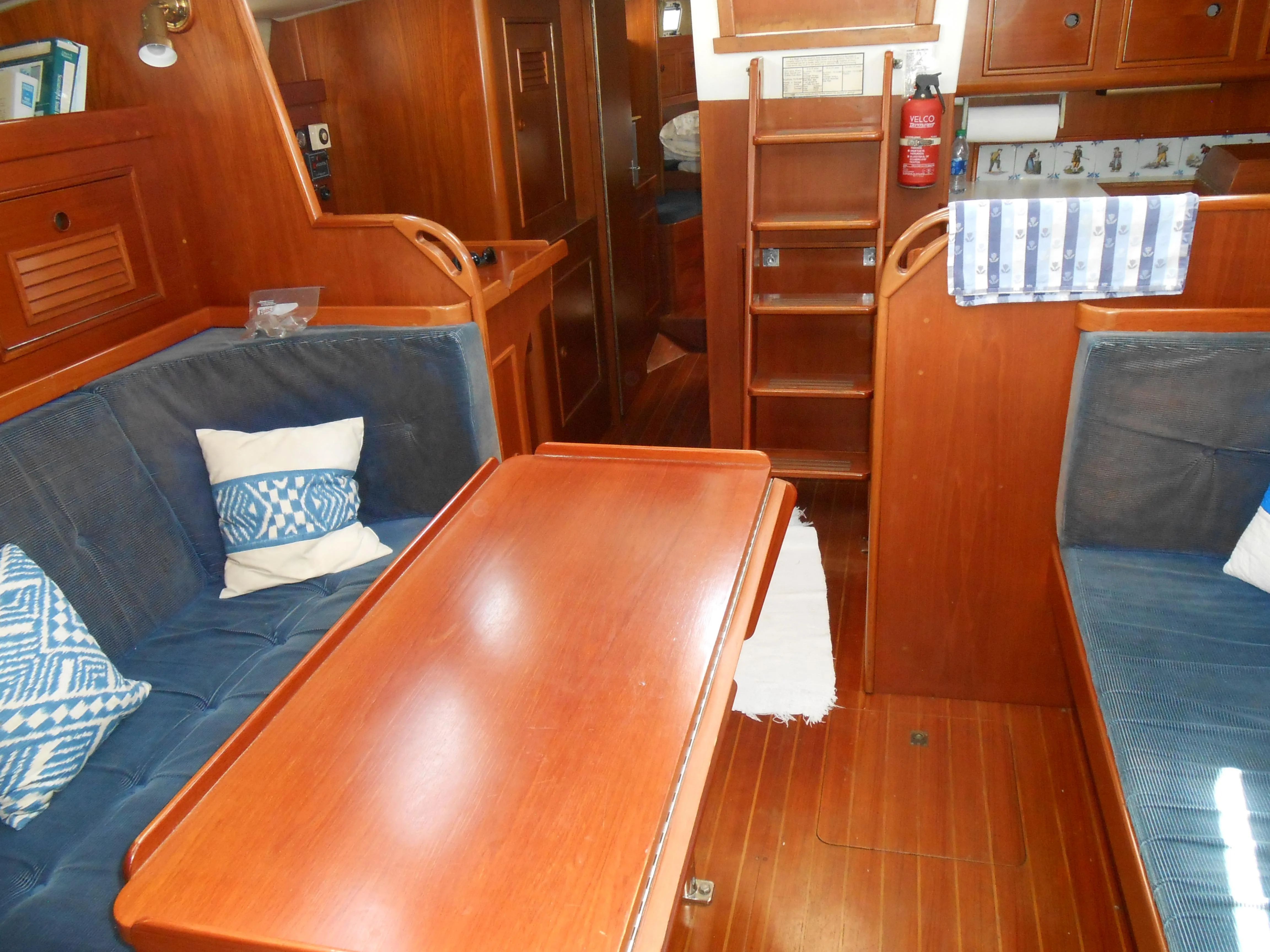 Interior of a 1985 Contest 41 Ketch with wooden furnishings and blue upholstery.