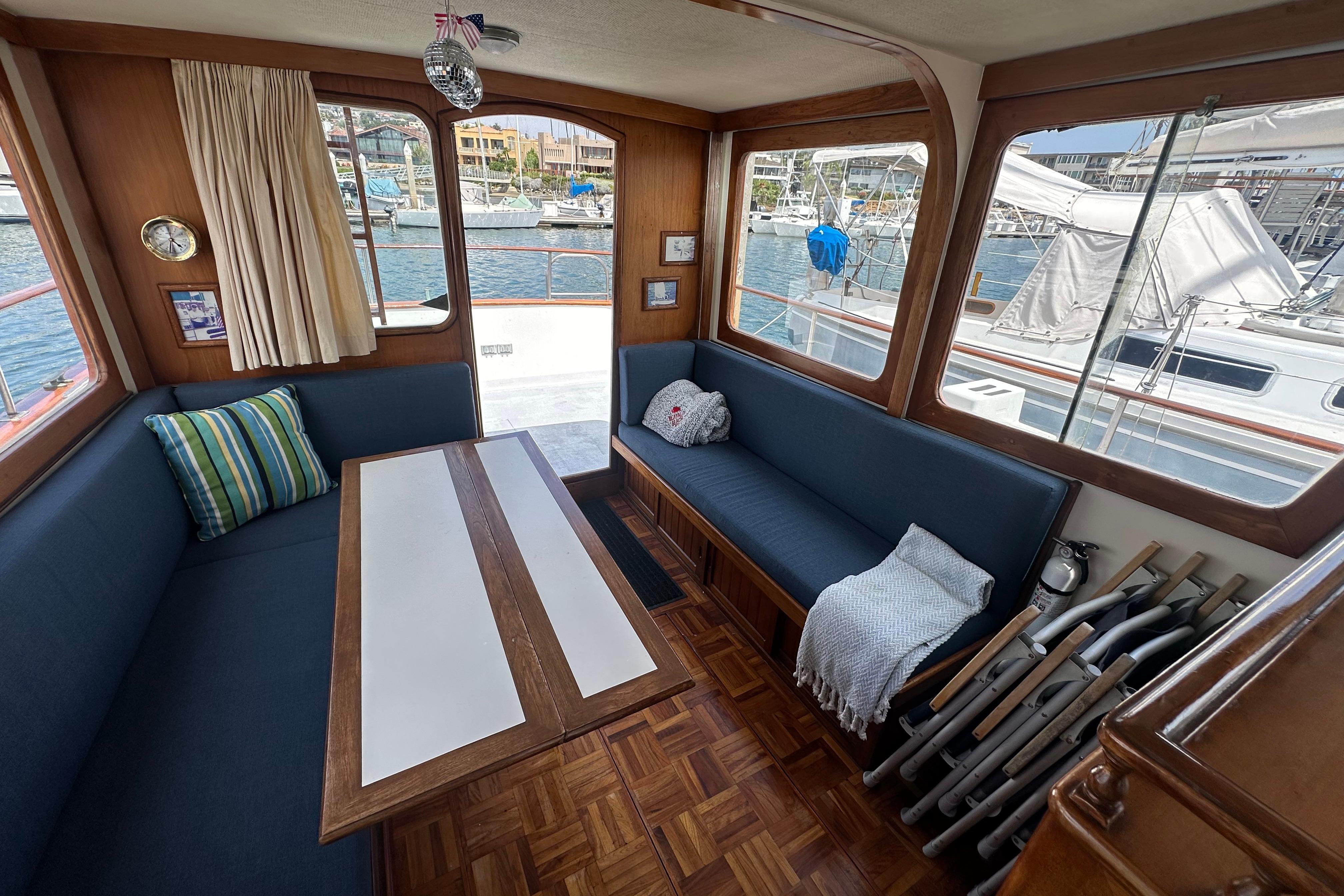 Interior of a 1973 CHB 33 boat with cozy seating and marina view.