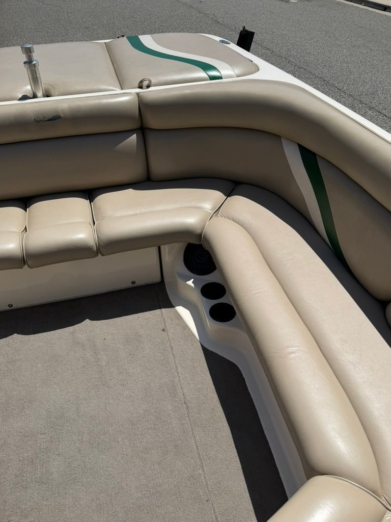 Interior of a boat with beige leather seats and green accents.