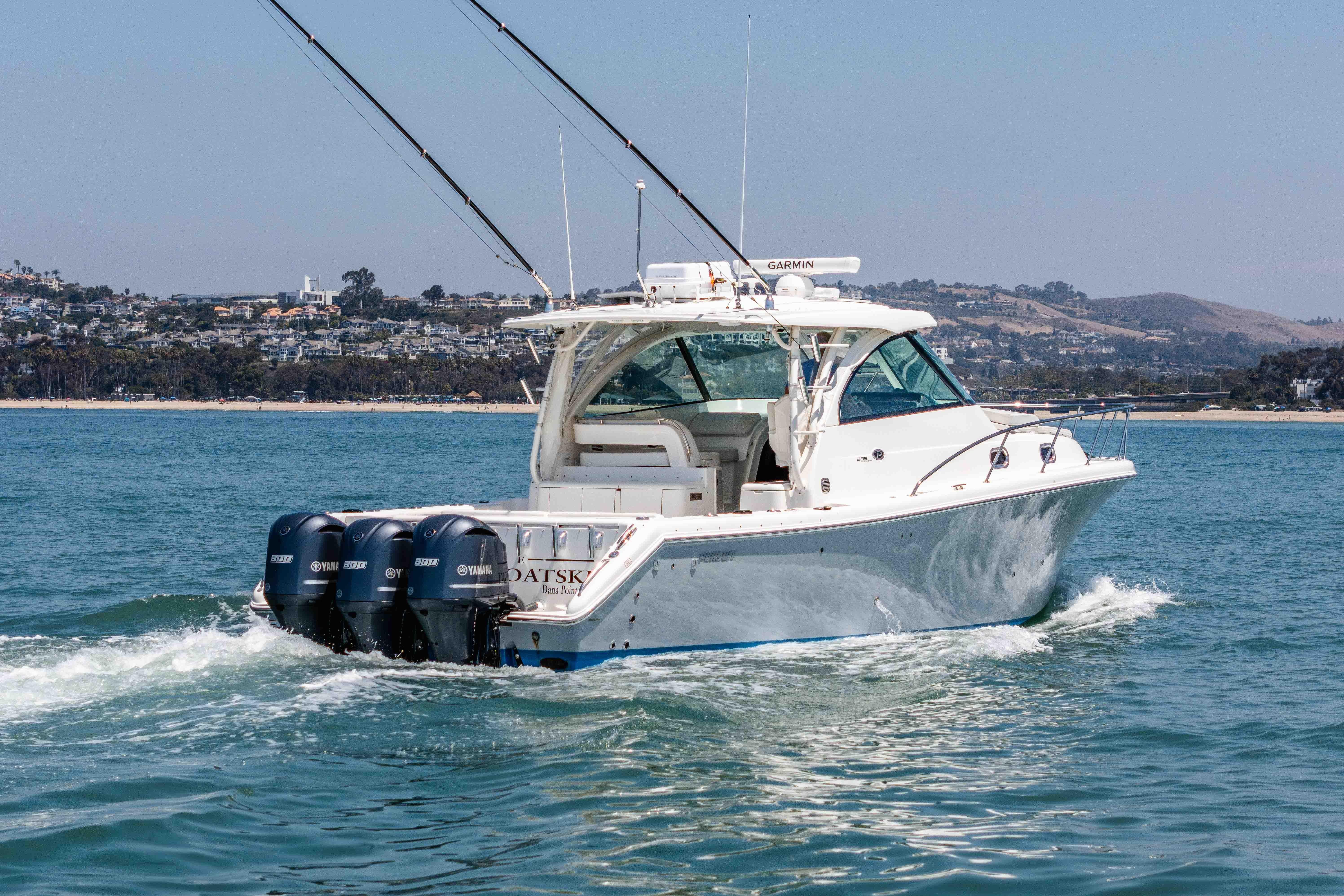 2022 Pursuit OS 385 Offshore boat cruising on open water with scenic coastal backdrop.