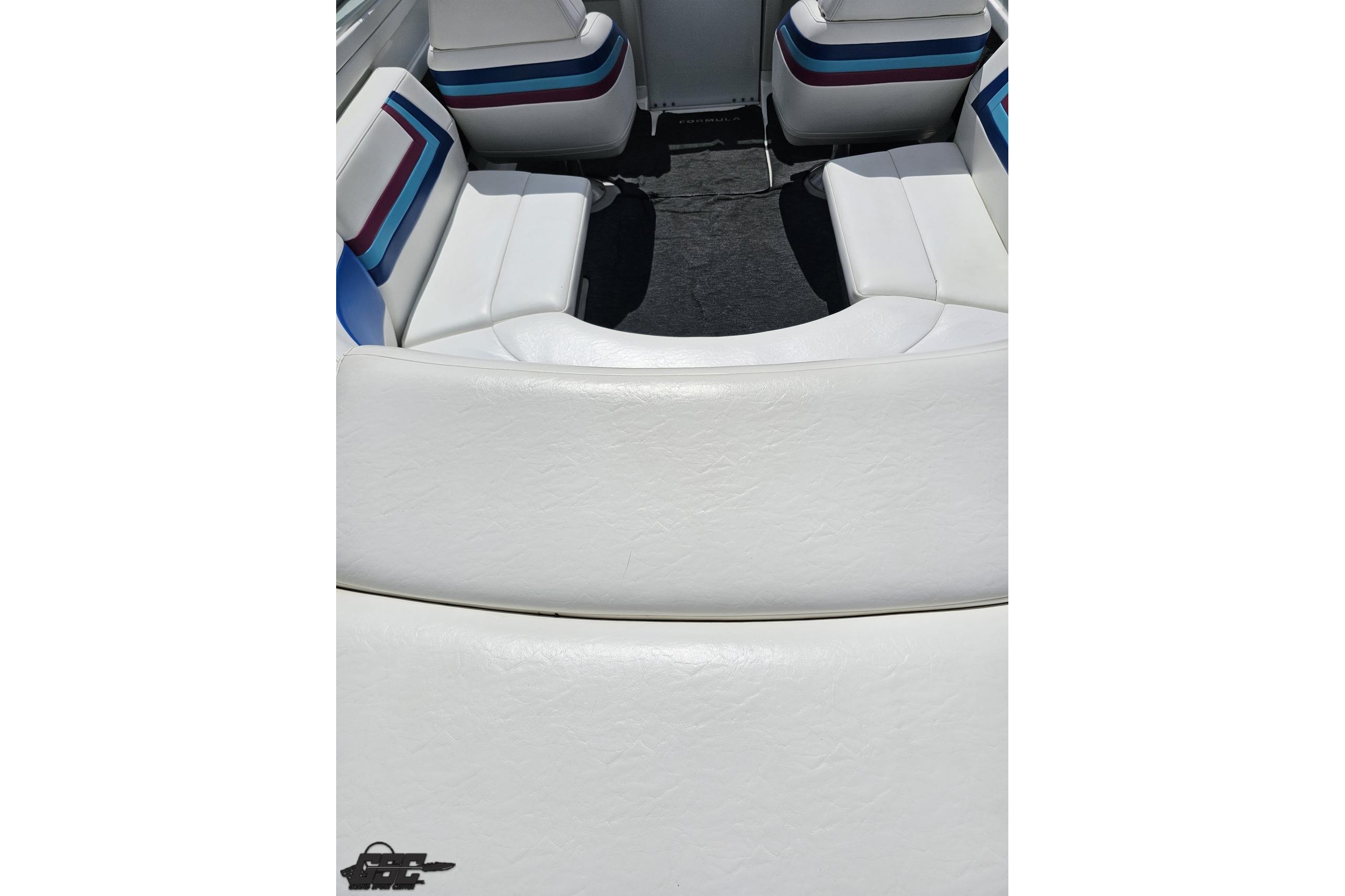 Interior seating of a 1997 Formula 252 SS boat with white upholstery and colorful accents.