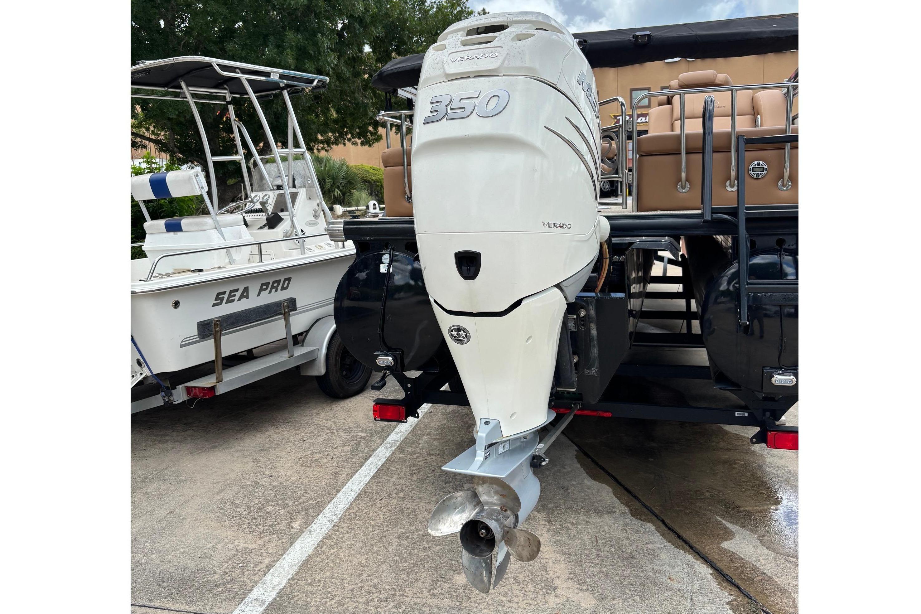 A boat with a large outboard motor parked on a trailer.