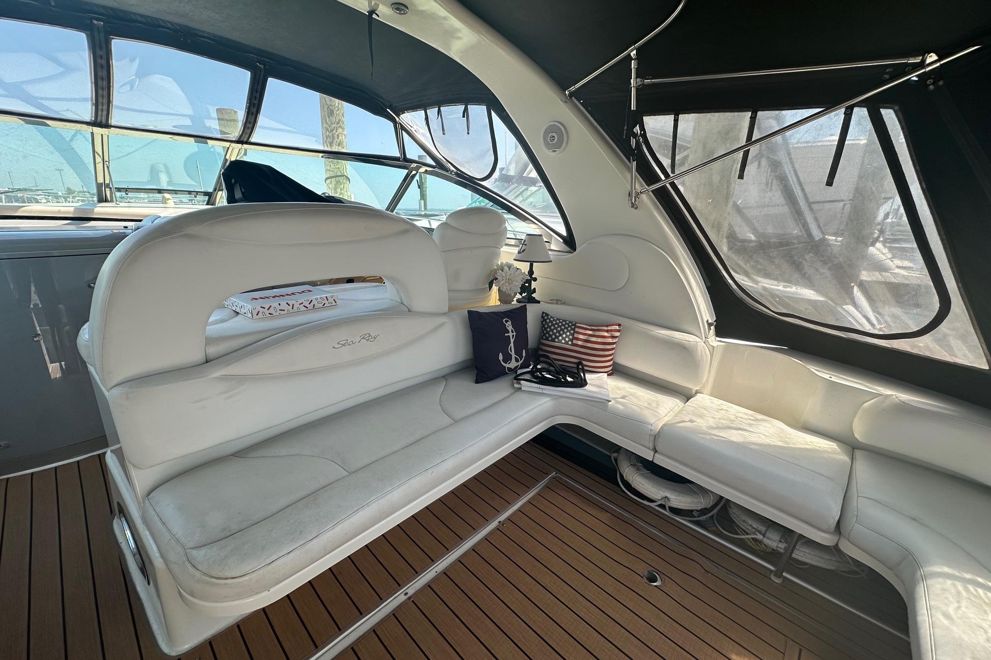 Luxurious interior of 2001 Sea Ray 410 Sundancer yacht with white seating and nautical decor.