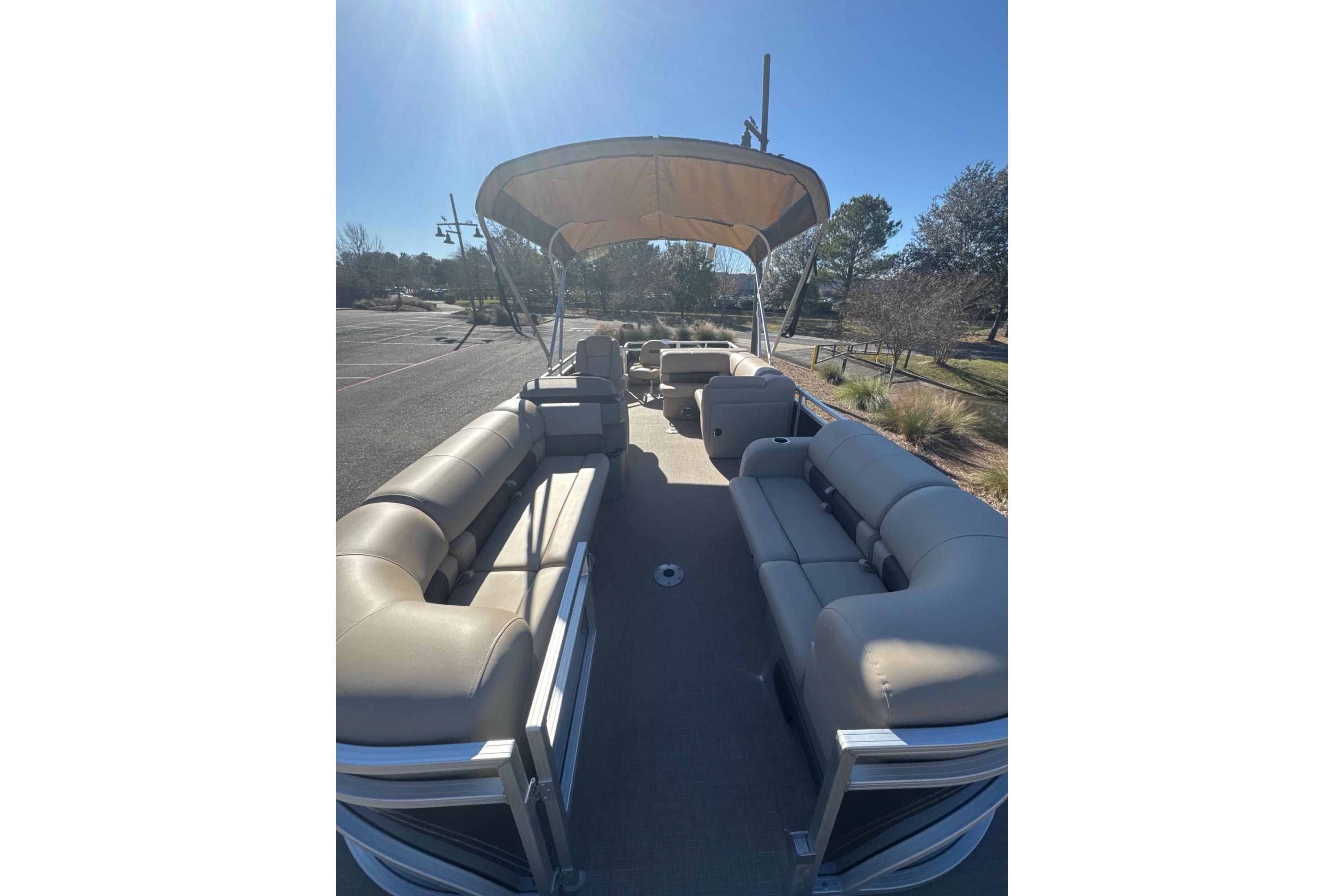 2025 Sun Tracker SportFish 22 DLX pontoon boat with spacious seating and canopy.