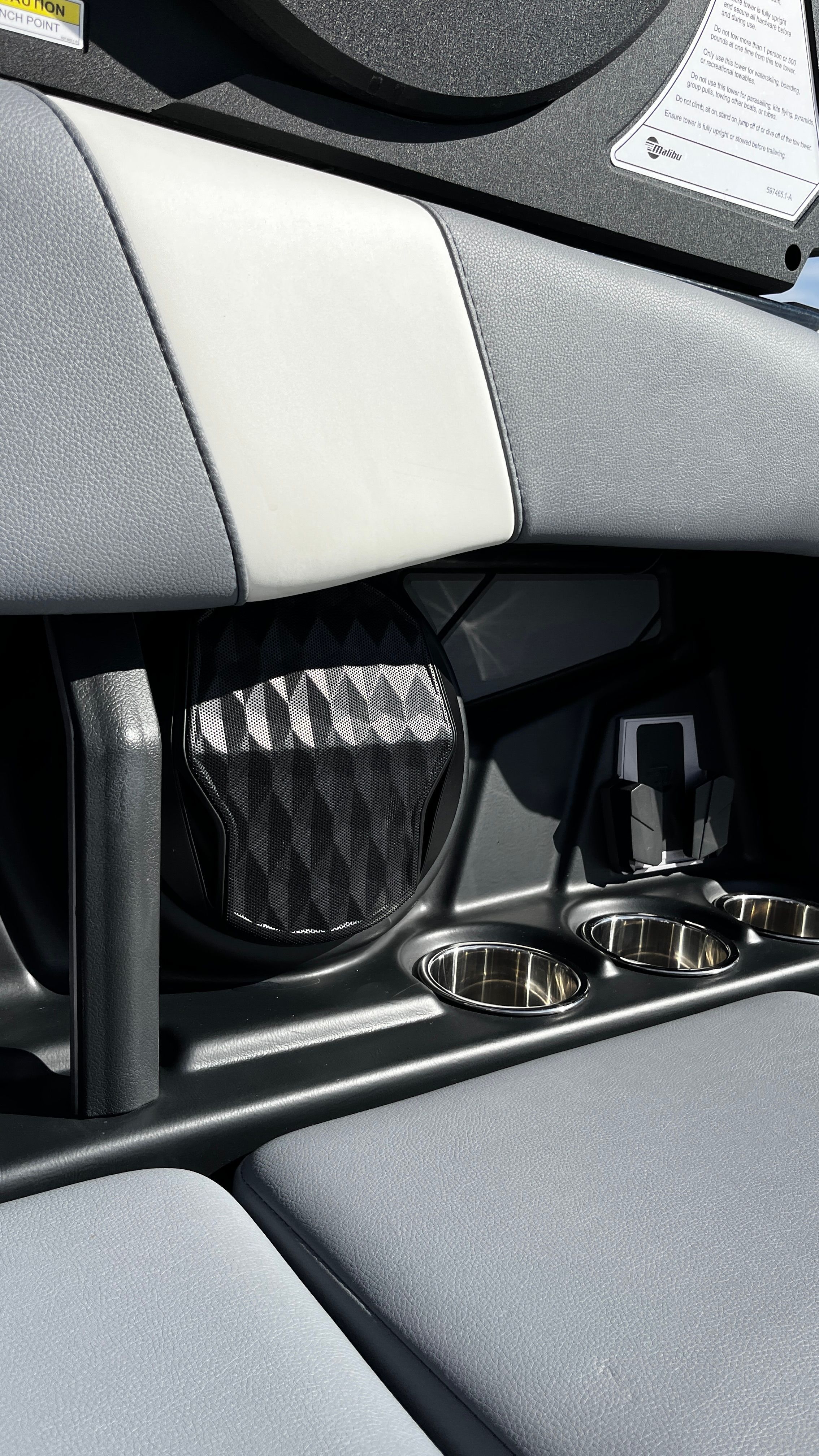 Close-up of a boat interior with gray upholstery and cup holders.