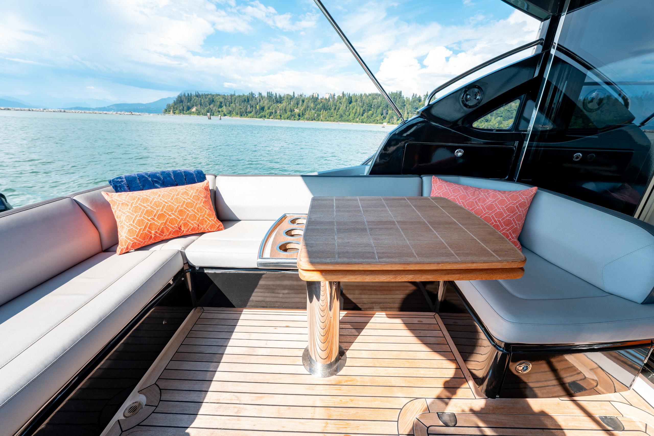 Luxurious seating area on 2015 Princess V48 yacht with scenic water view.