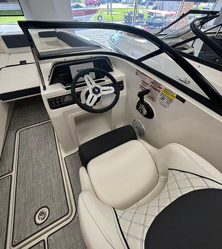 2024 Bayliner DX 2050 boat interior with steering wheel and seating.