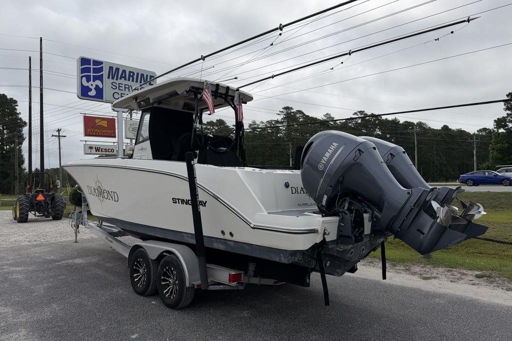 2023 Stingray 273 CC boat on trailer at marine service center with Yamaha outboard.