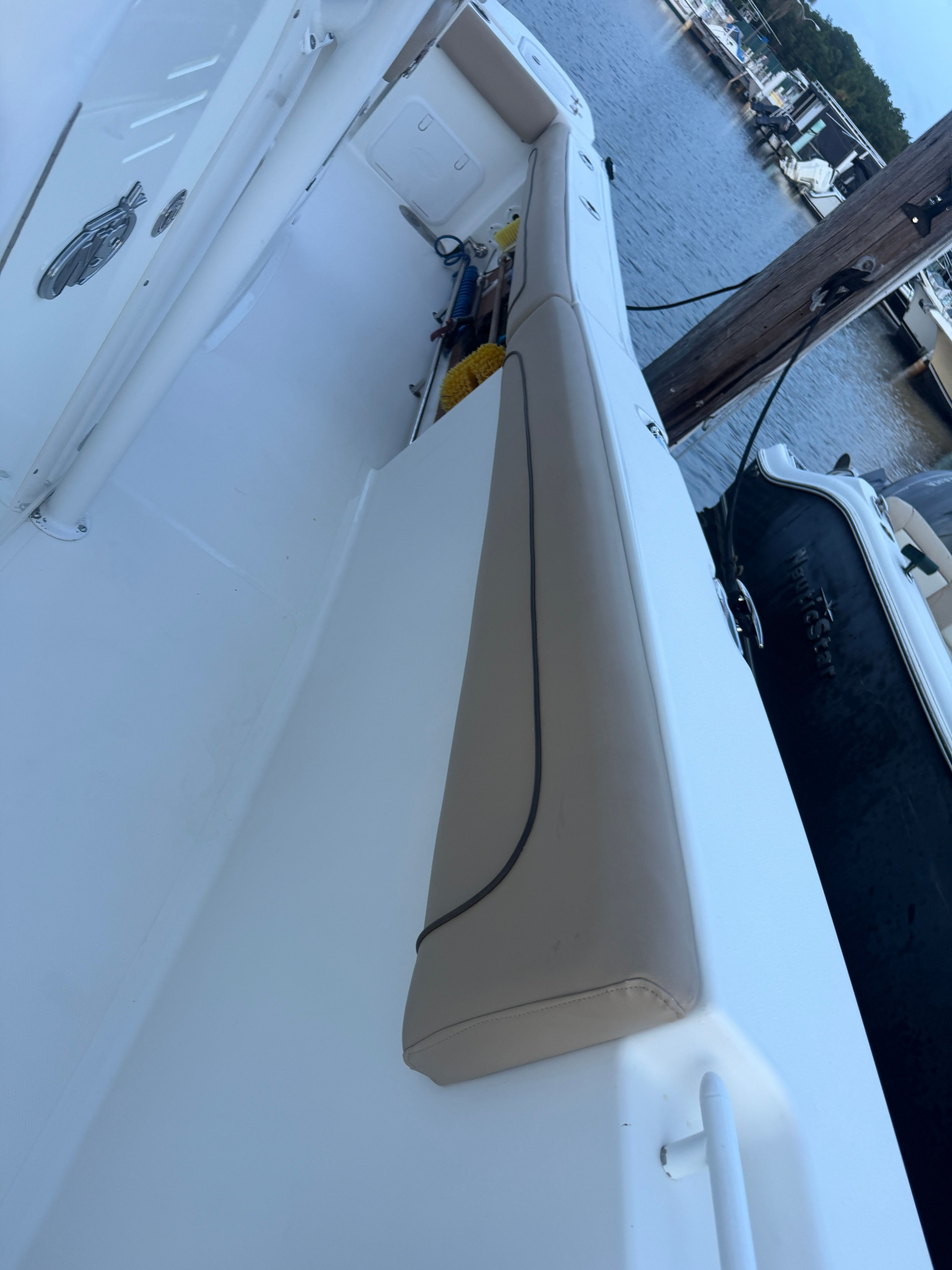 The image shows the deck of a 2019 NauticStar 28 XS boat at a marina.