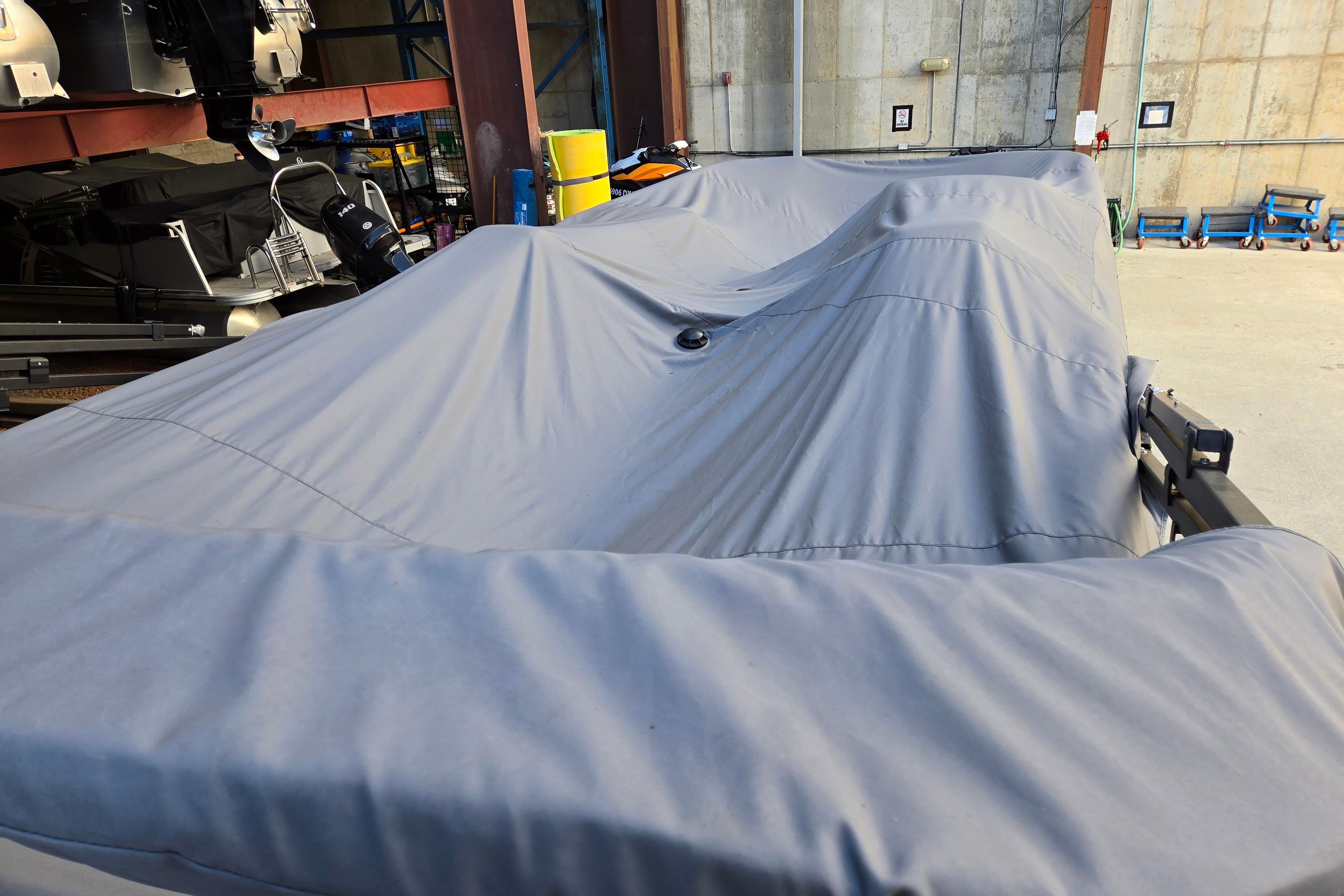Covered 2024 Godfrey Sweetwater 2486 SB boat in storage facility.