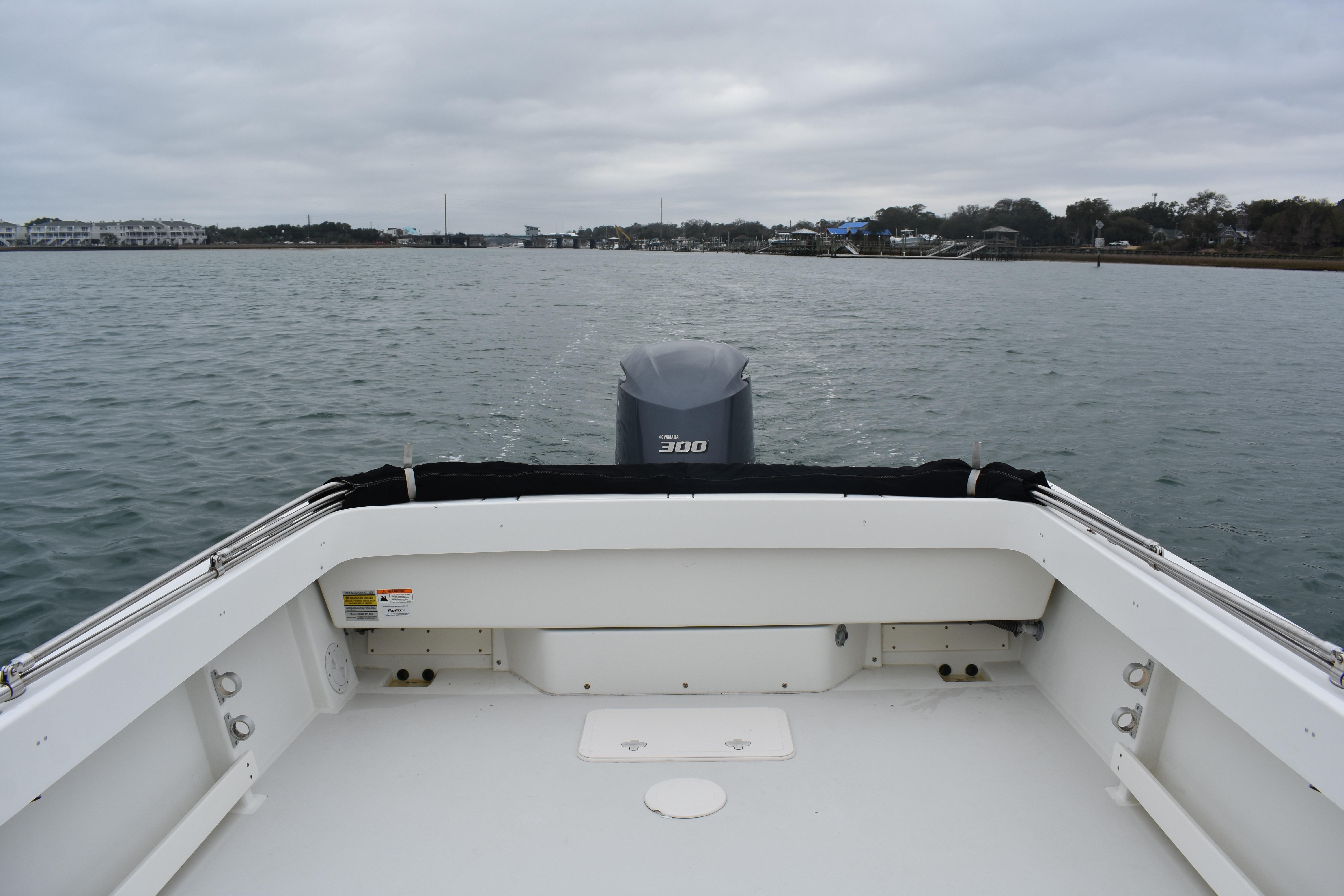 2015 Parker 2320 SL Sport Cabin boat on calm water, overcast sky.