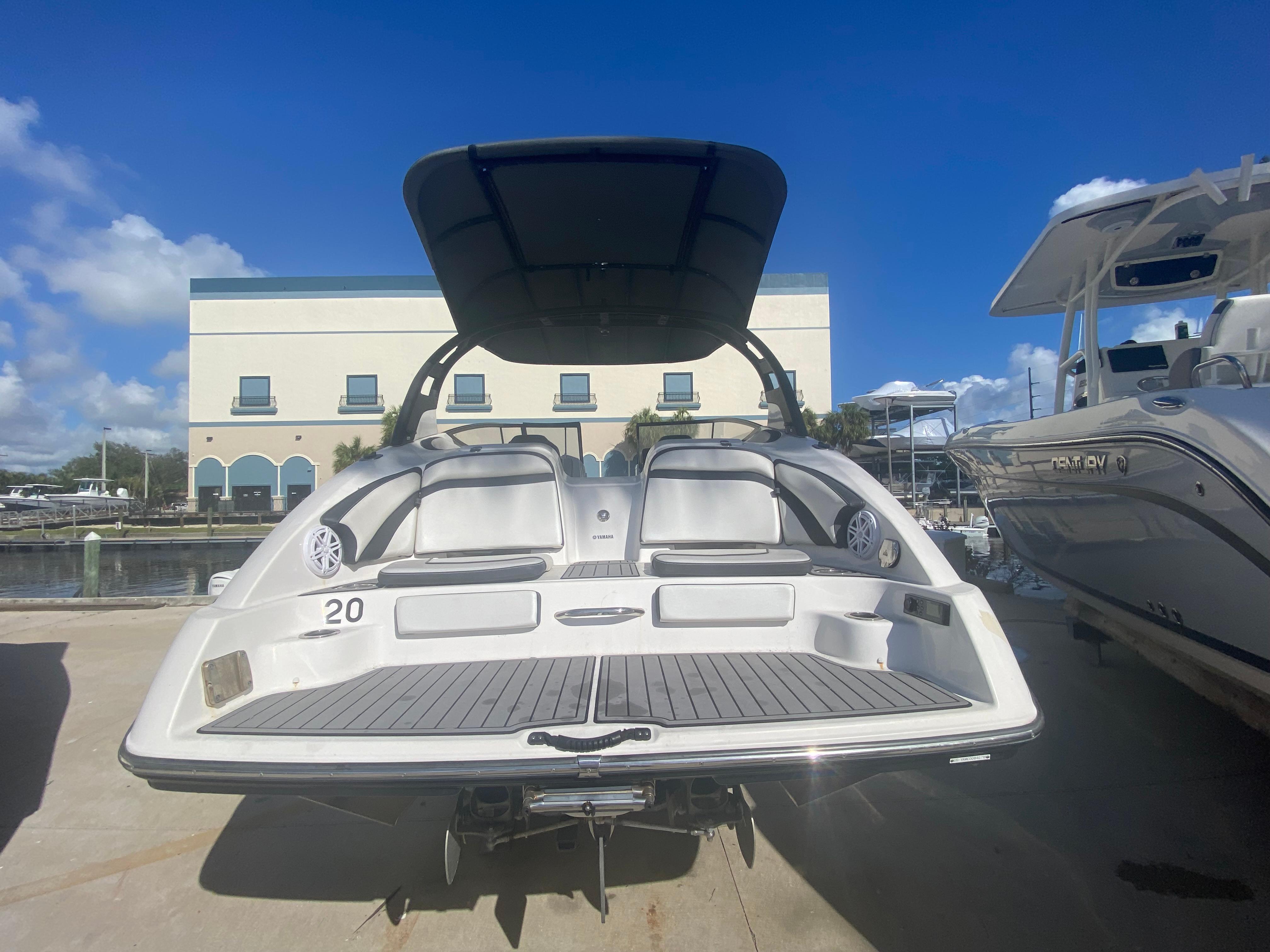 2018 Yamaha Boats 242 Limited S at marina, rear view under sunny sky.
