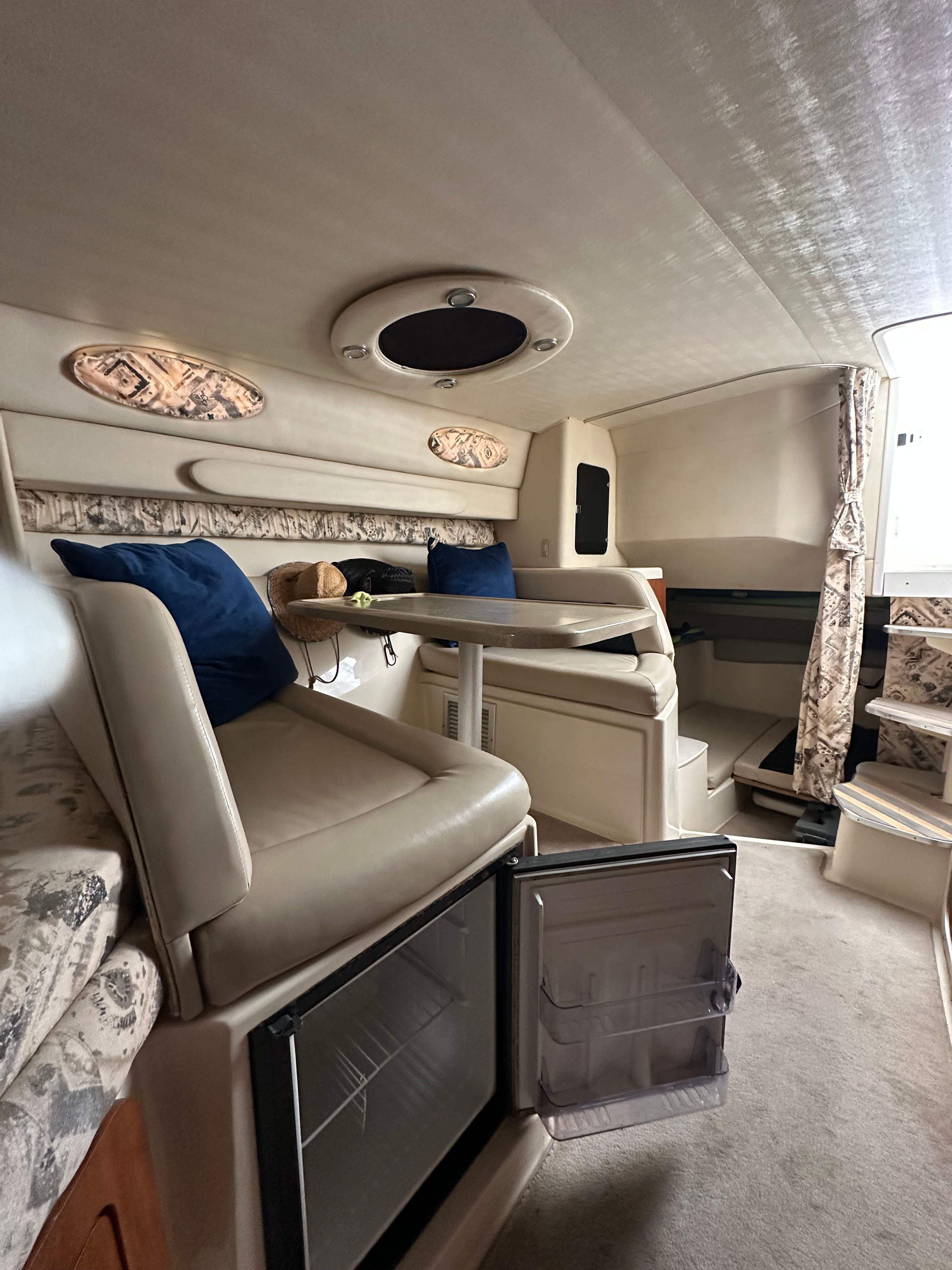 Interior of a 1999 Wellcraft 3000 Martinique yacht with seating area and fridge.