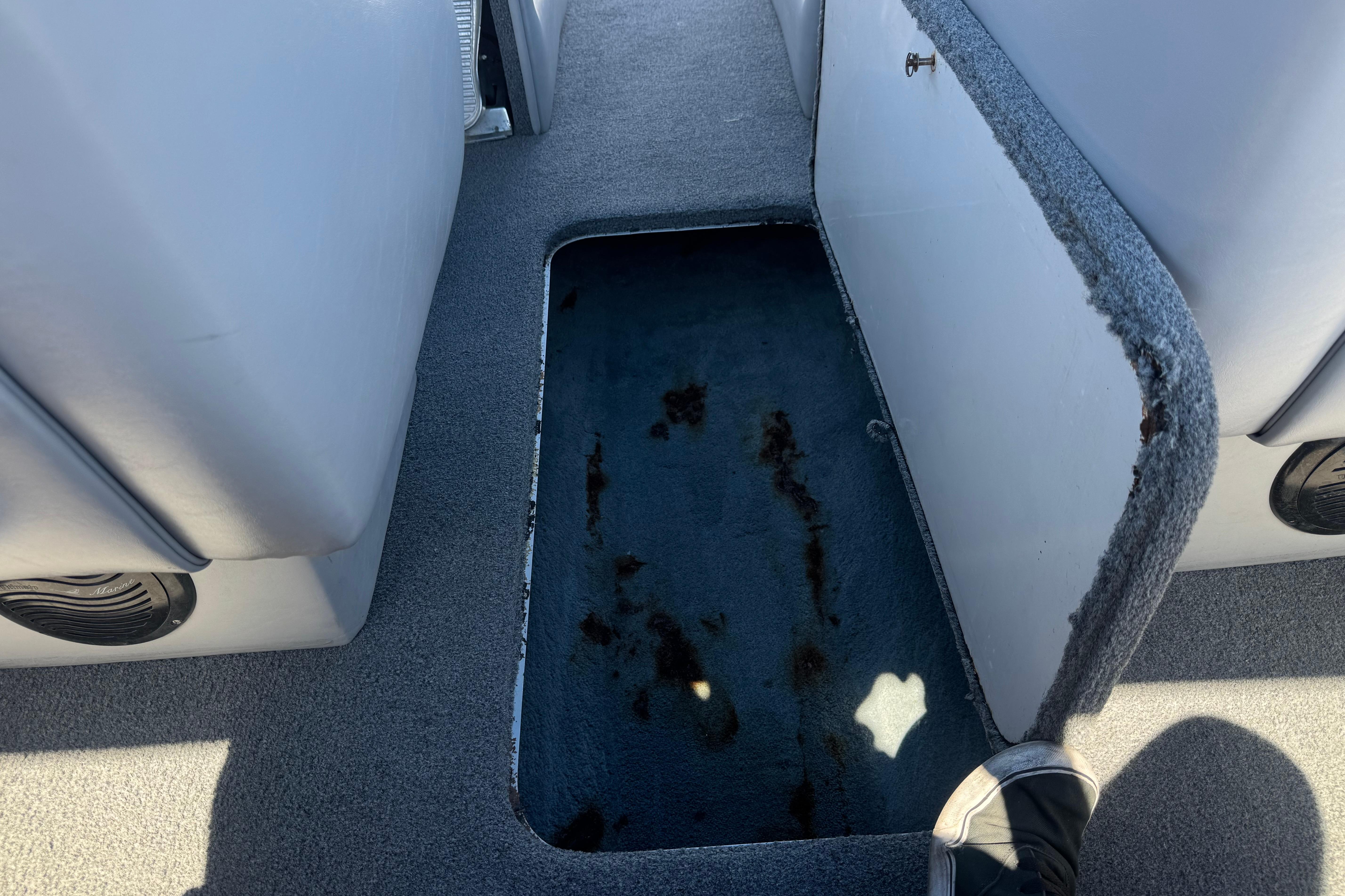 Open storage compartment in 2007 Commander 2300LX boat interior, showing carpeted floor.