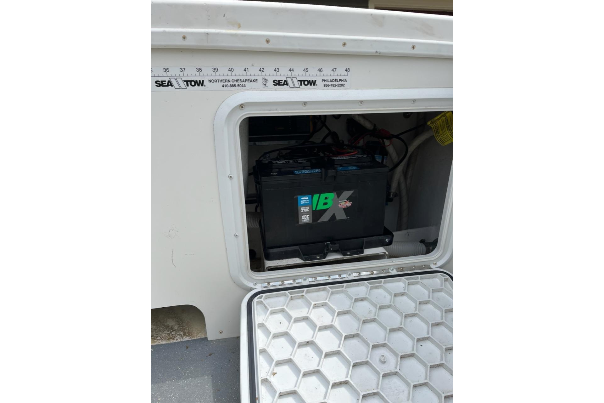 Battery compartment of a 2012 Steiger Craft Miami boat, featuring a marine battery.