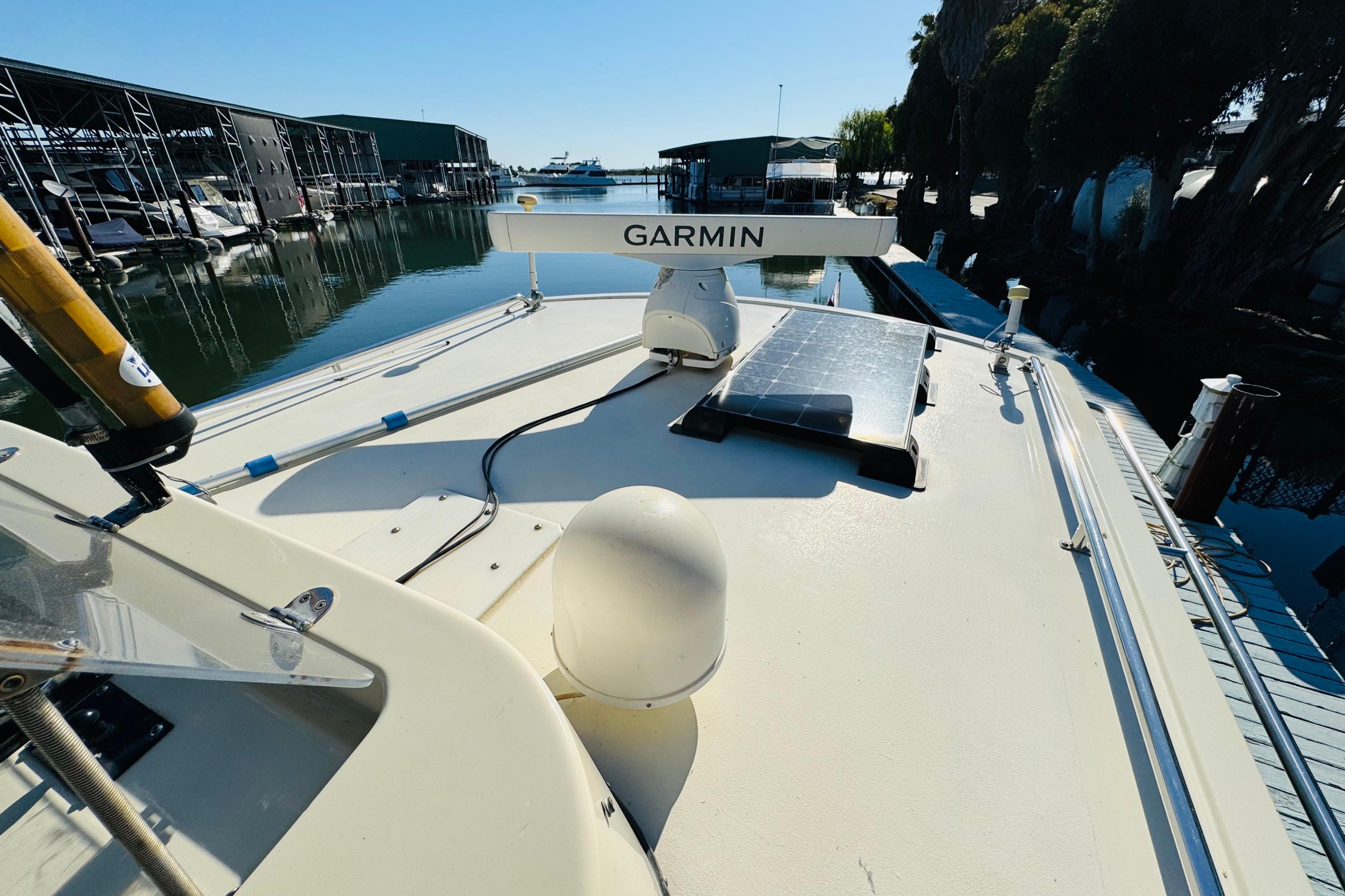 1996 Nordic Tug 32 boat with Garmin radar and solar panel at marina dock.