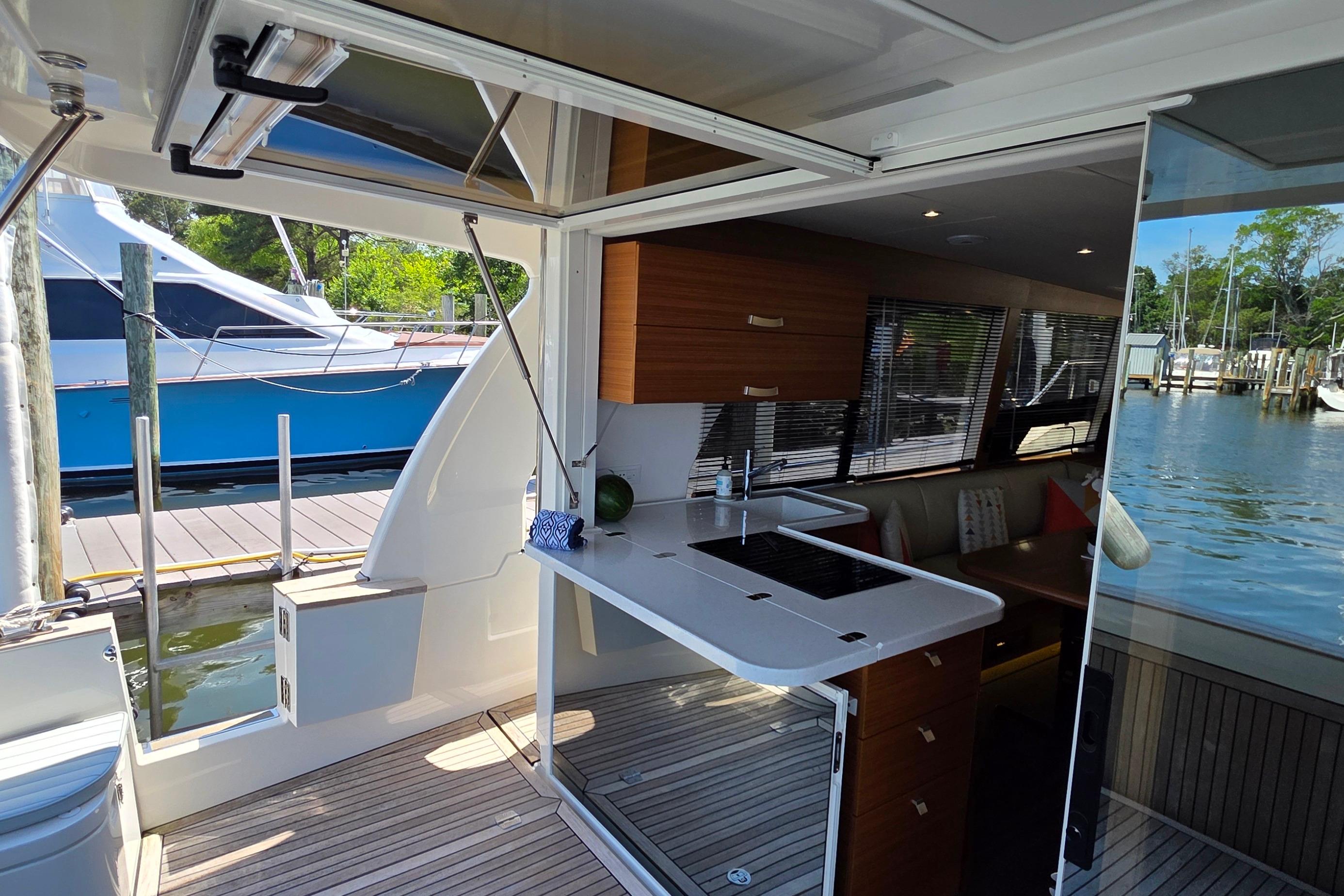 Modern Greenline 40 yacht interior with sleek kitchen, docked by serene waters, 2023 model.