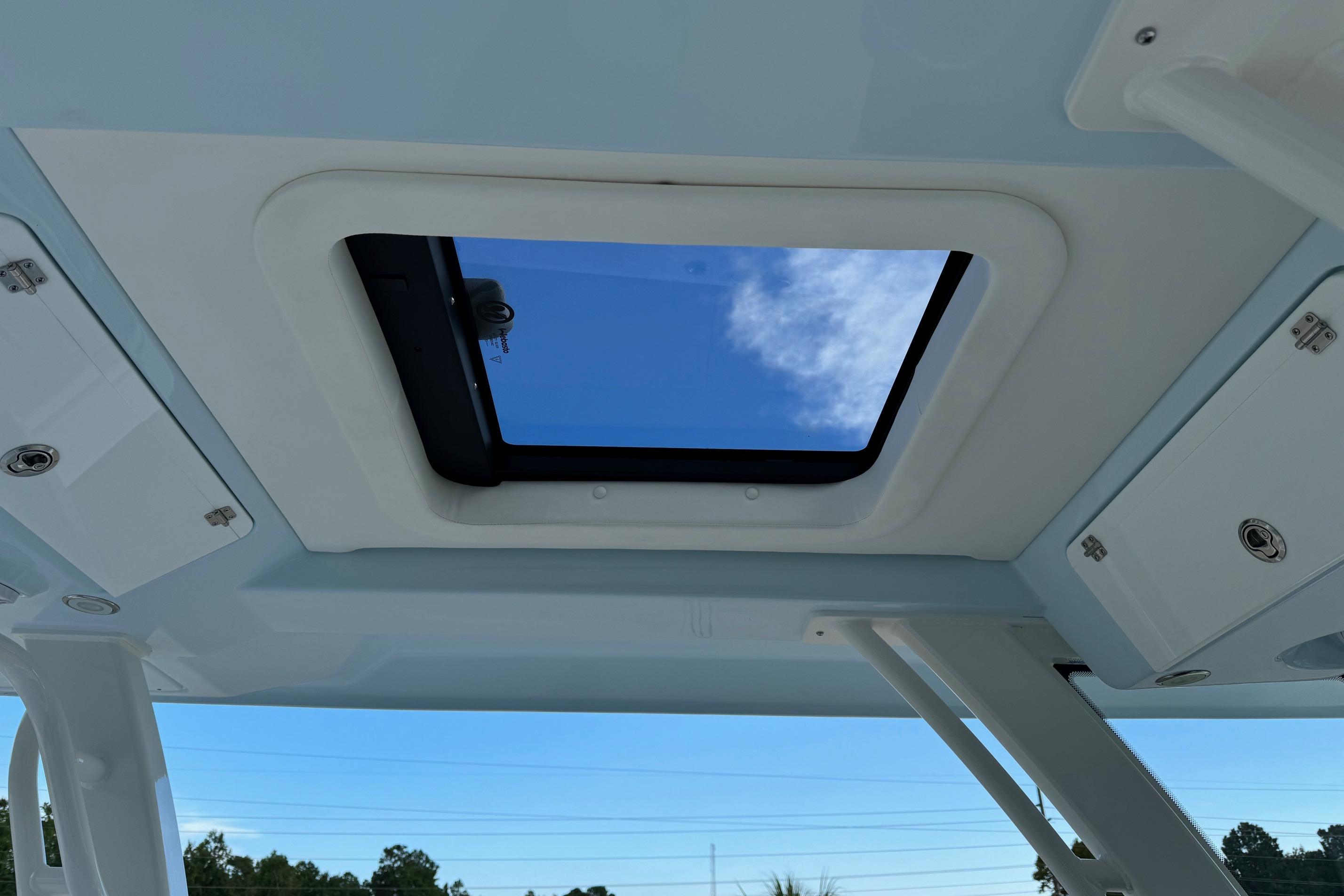 2025 Robalo R360 Center Console boat skylight view with blue sky and clouds.