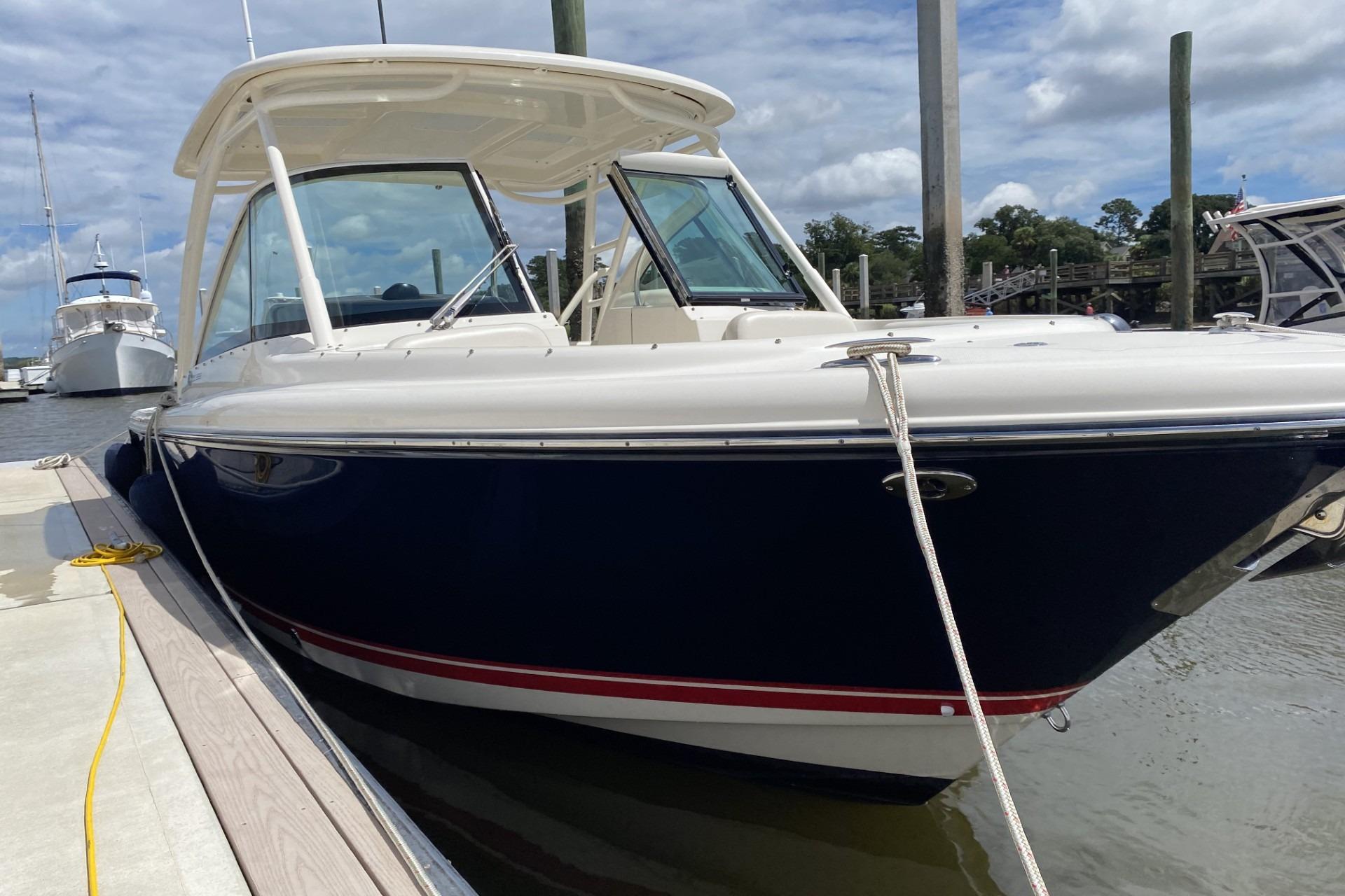 2013 Pursuit DC 265 Dual Console boat docked at marina under cloudy sky.
