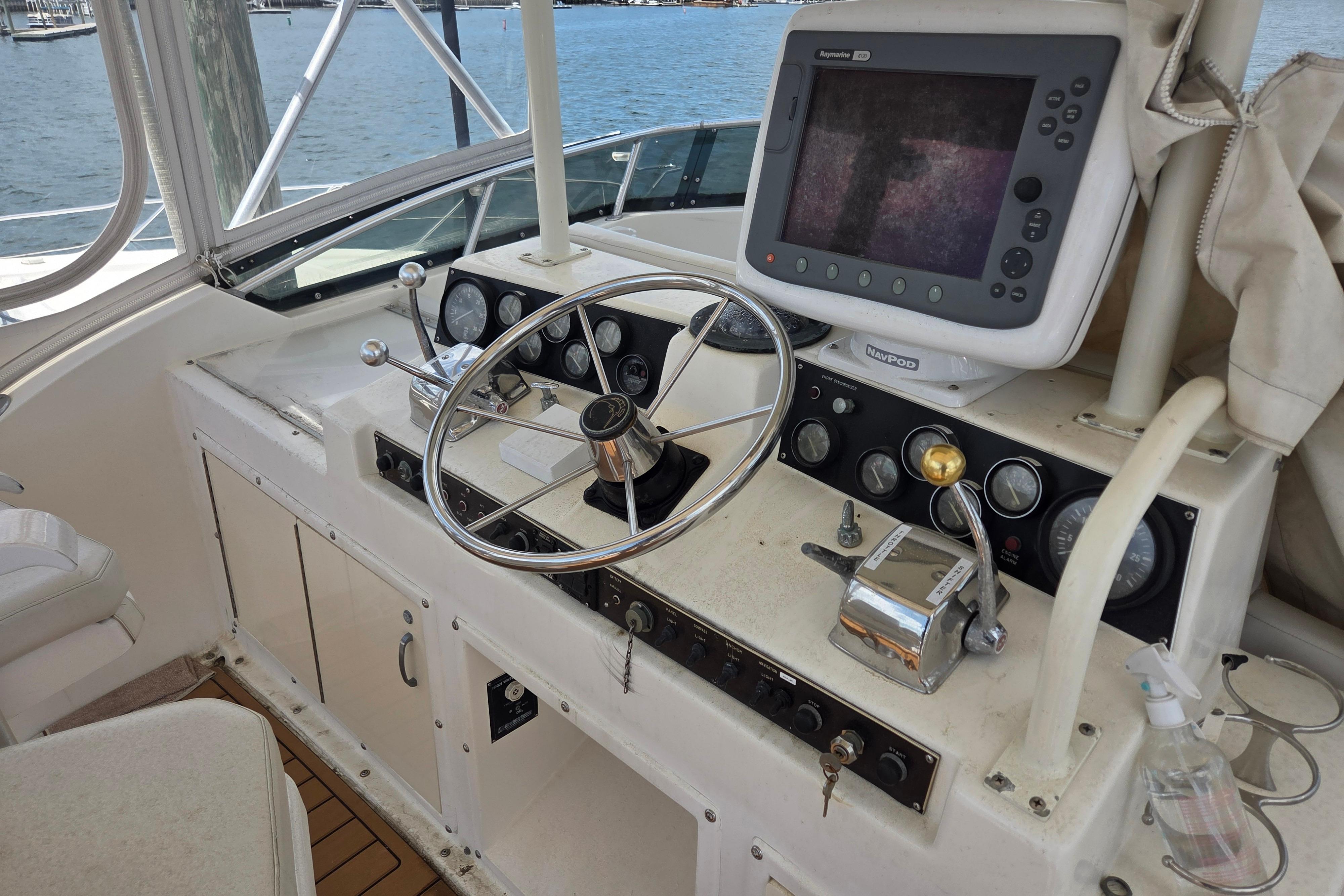 Cockpit of 1990 Egg Harbor Golden Egg 42 with steering wheel and navigation equipment.