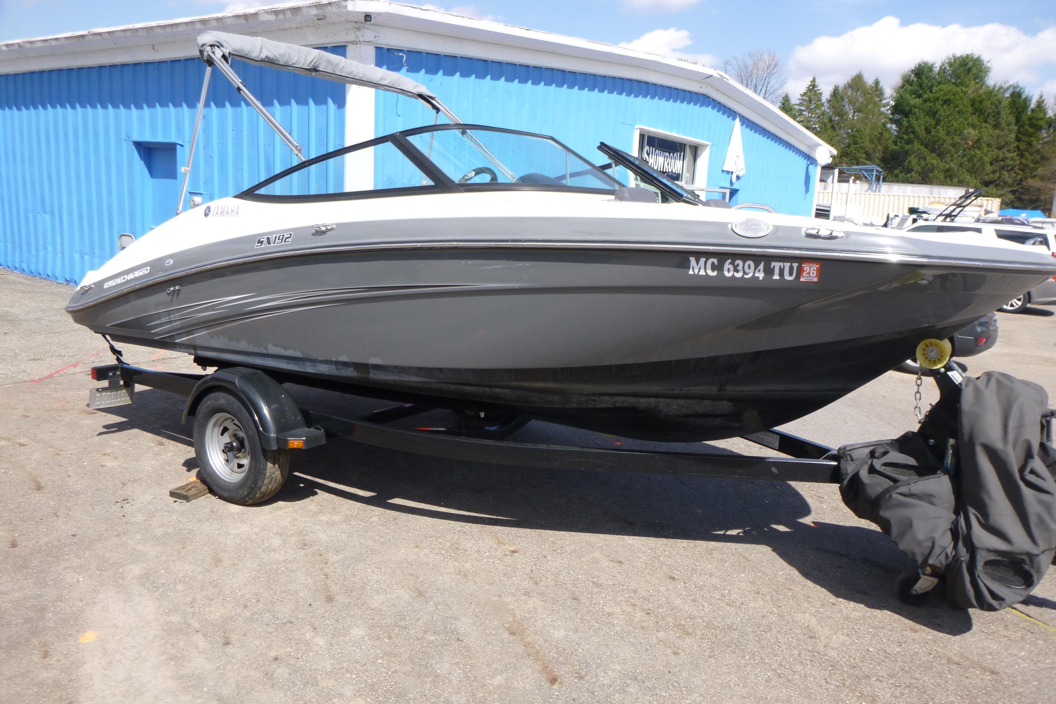 2015 Yamaha Boats SX192 on trailer, parked outside a blue building.