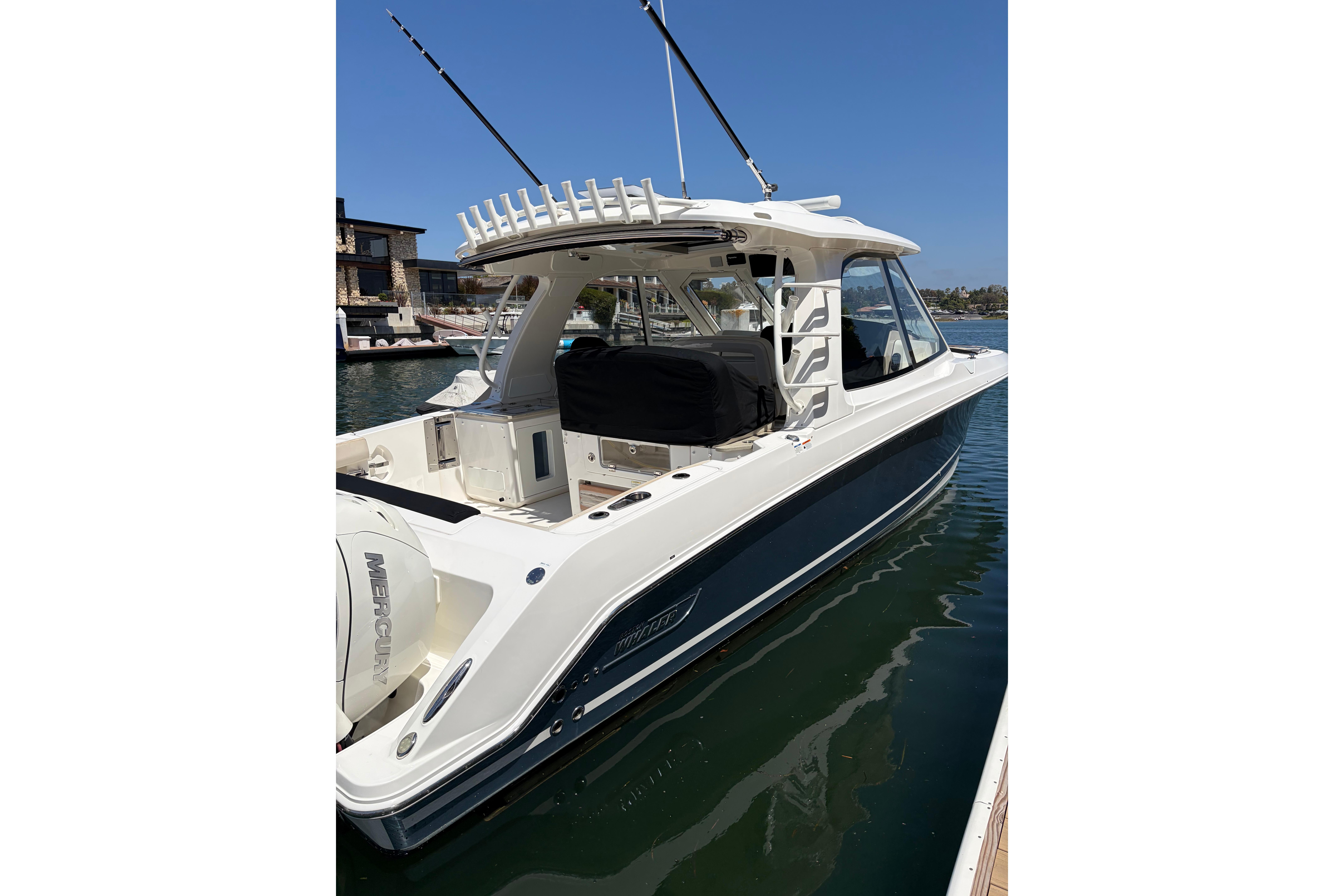 2020 Boston Whaler 380 Realm boat docked in marina, showcasing sleek design and fishing rods.