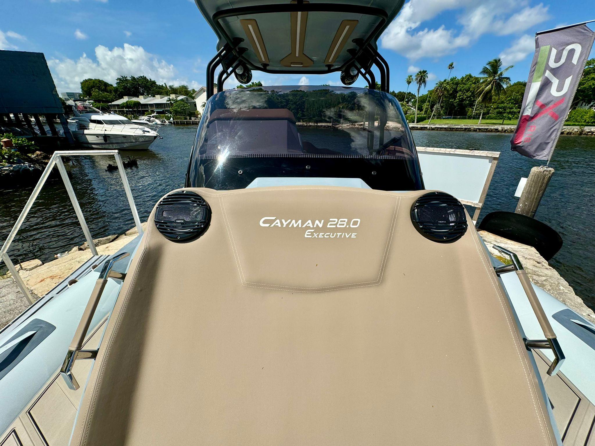 2025 Ranieri CAYMAN 28 EXECUTIVE boat docked by a scenic waterfront.