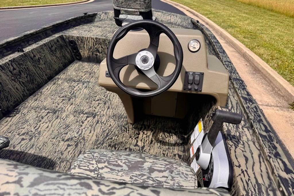 2026 Tracker Grizzly 1754 SC boat interior with camouflage design and steering console.
