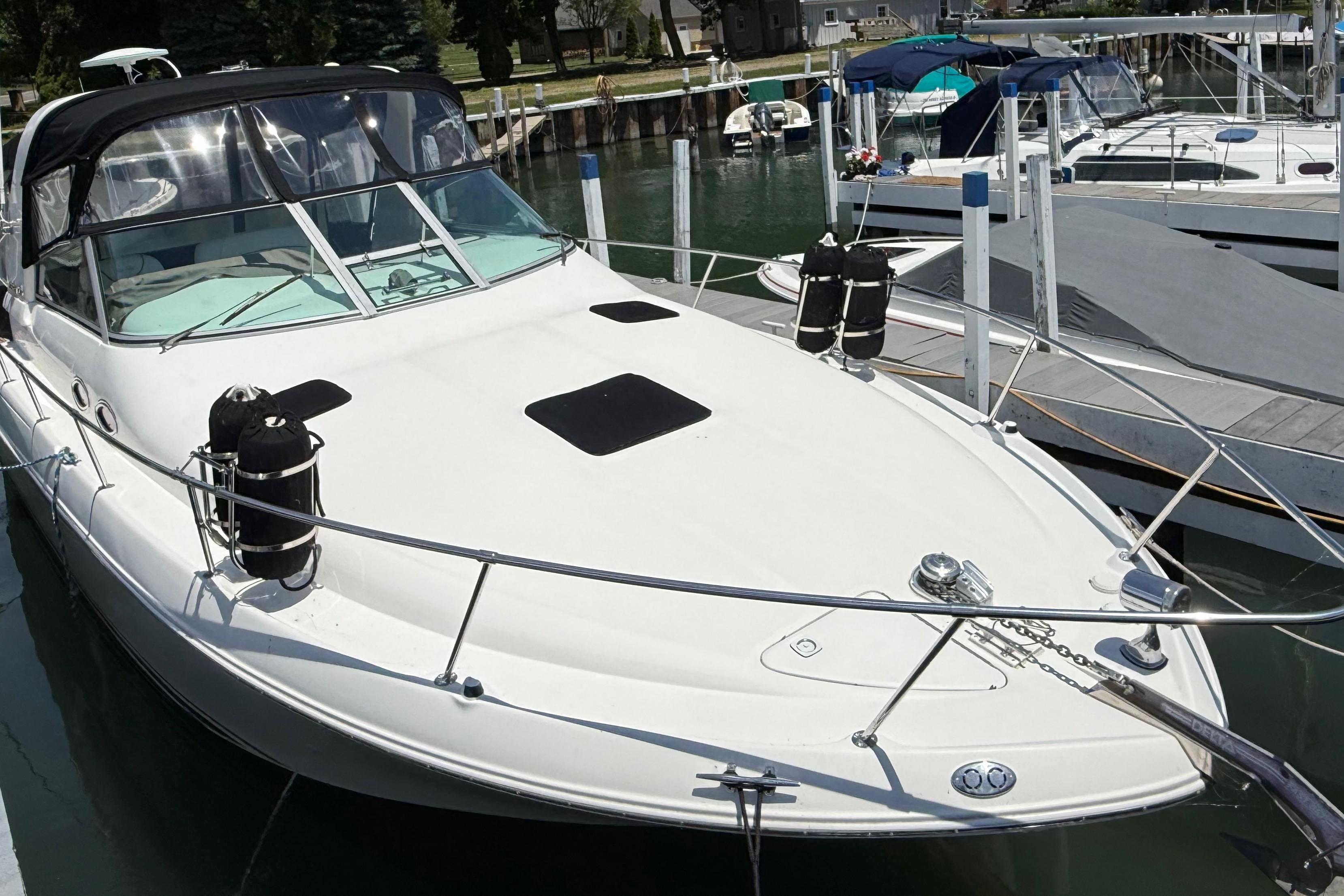 1999 Sea Ray Sundancer 310 docked at marina, featuring sleek white design.