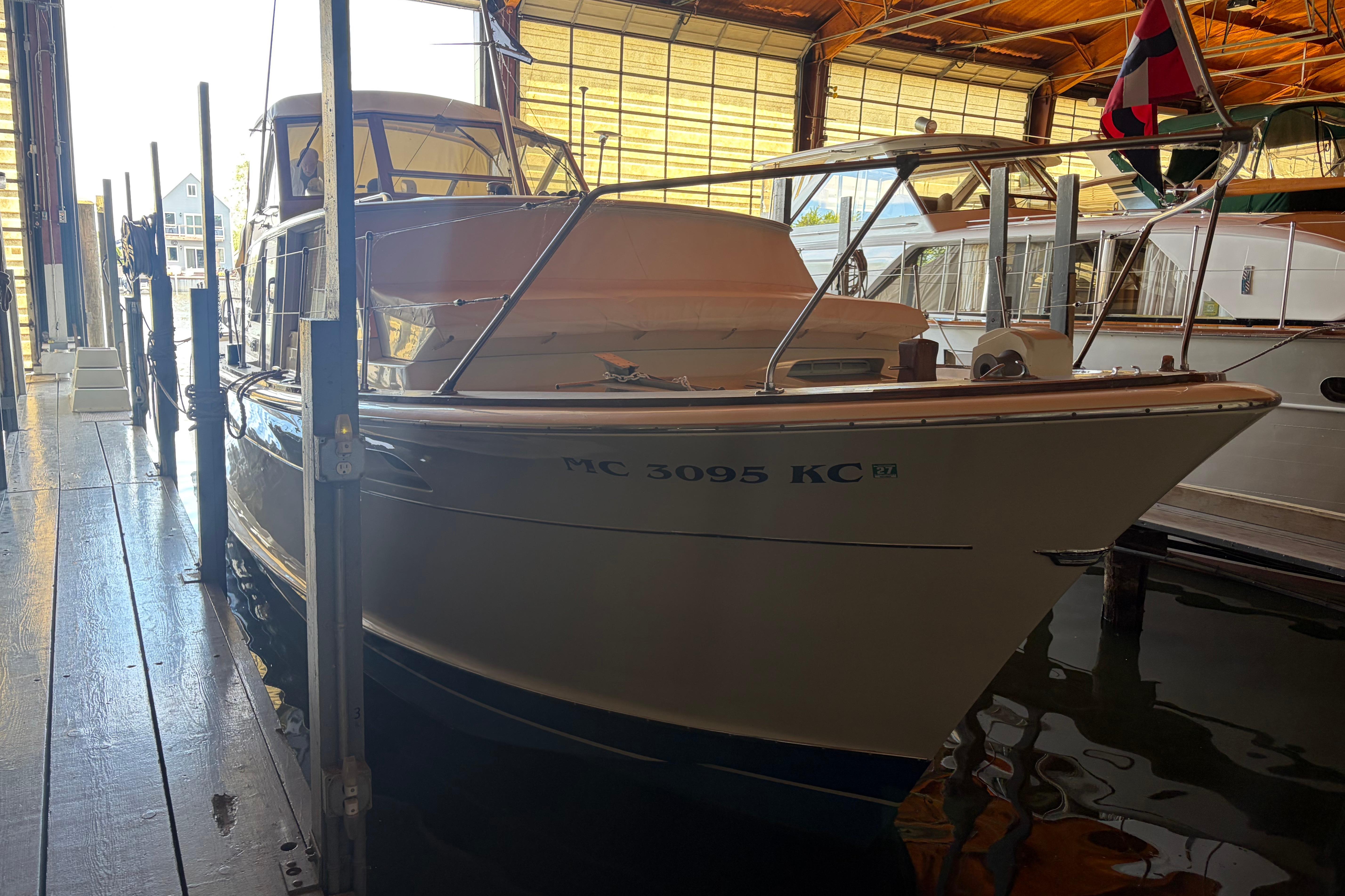 1971 Chris-Craft 42 Commander docked in a marina, partially illuminated.