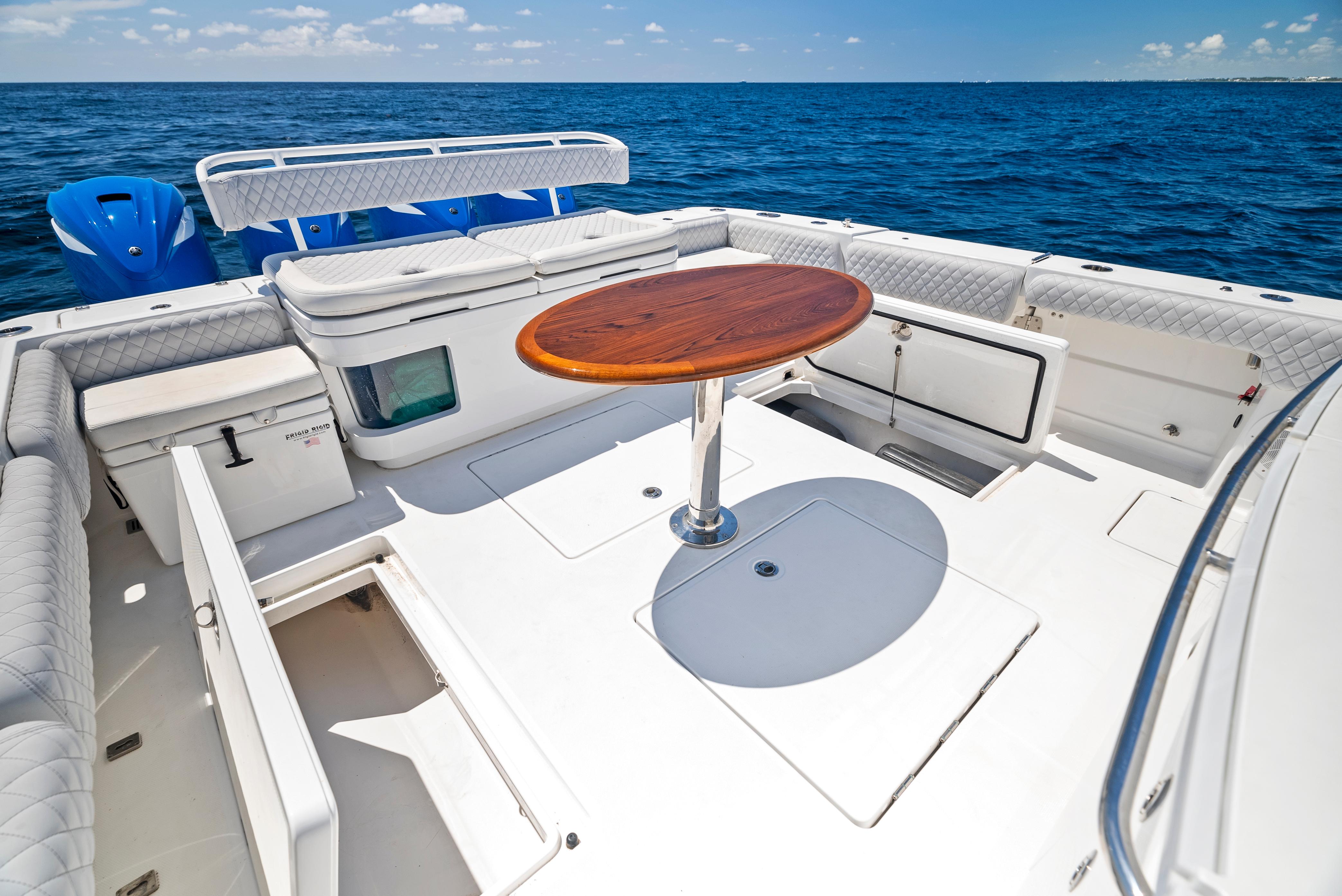 2022 HCB Suenos boat deck with seating and wooden table on open sea.