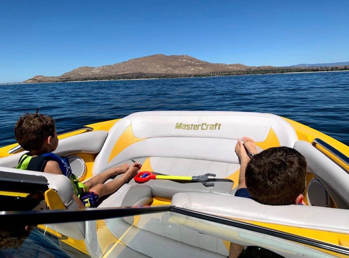 Children relaxing on a 2007 MasterCraft X-2 boat on the water.
