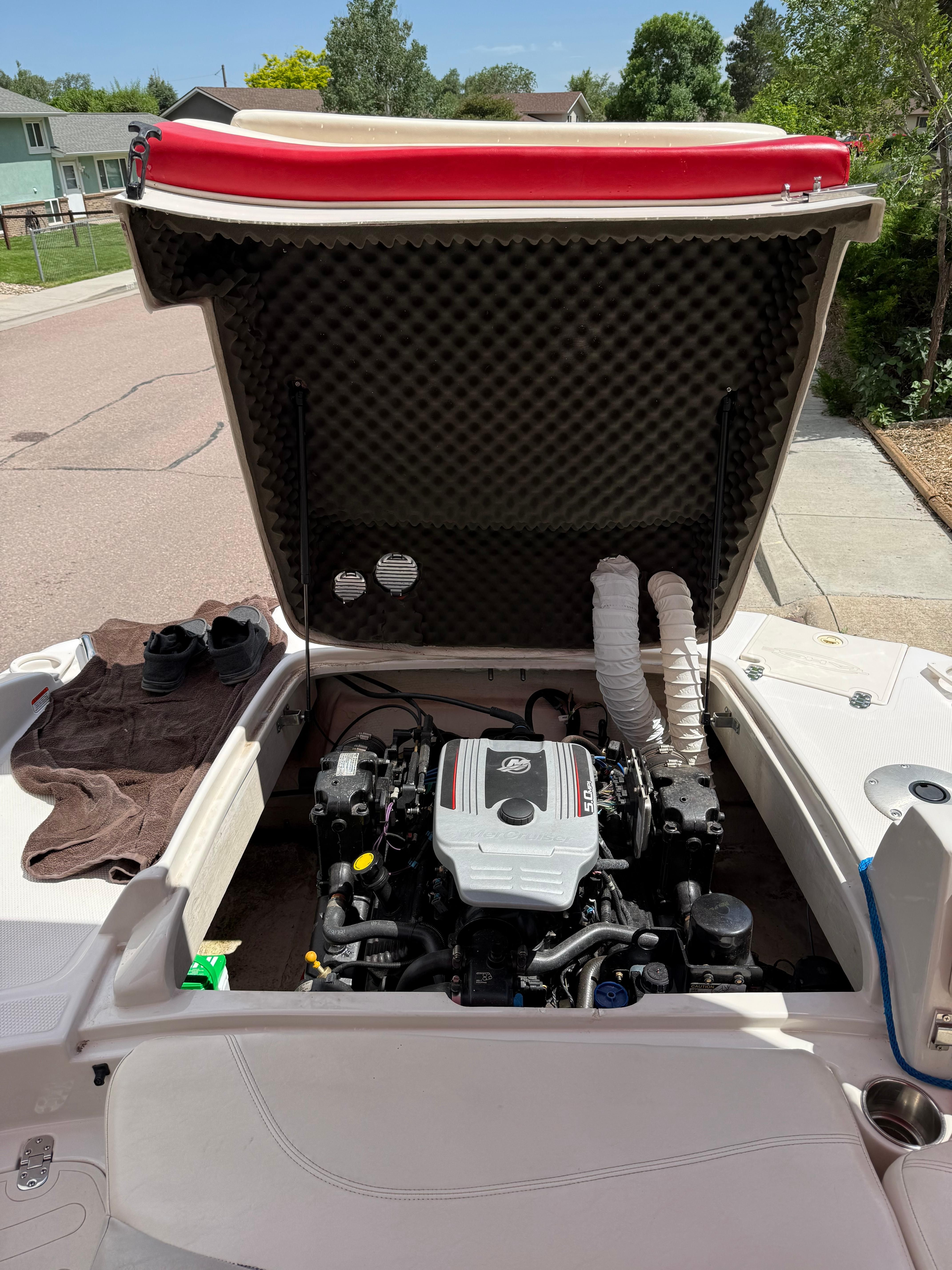 Engine compartment of a 2011 Tahoe 216 WT boat with open hatch.