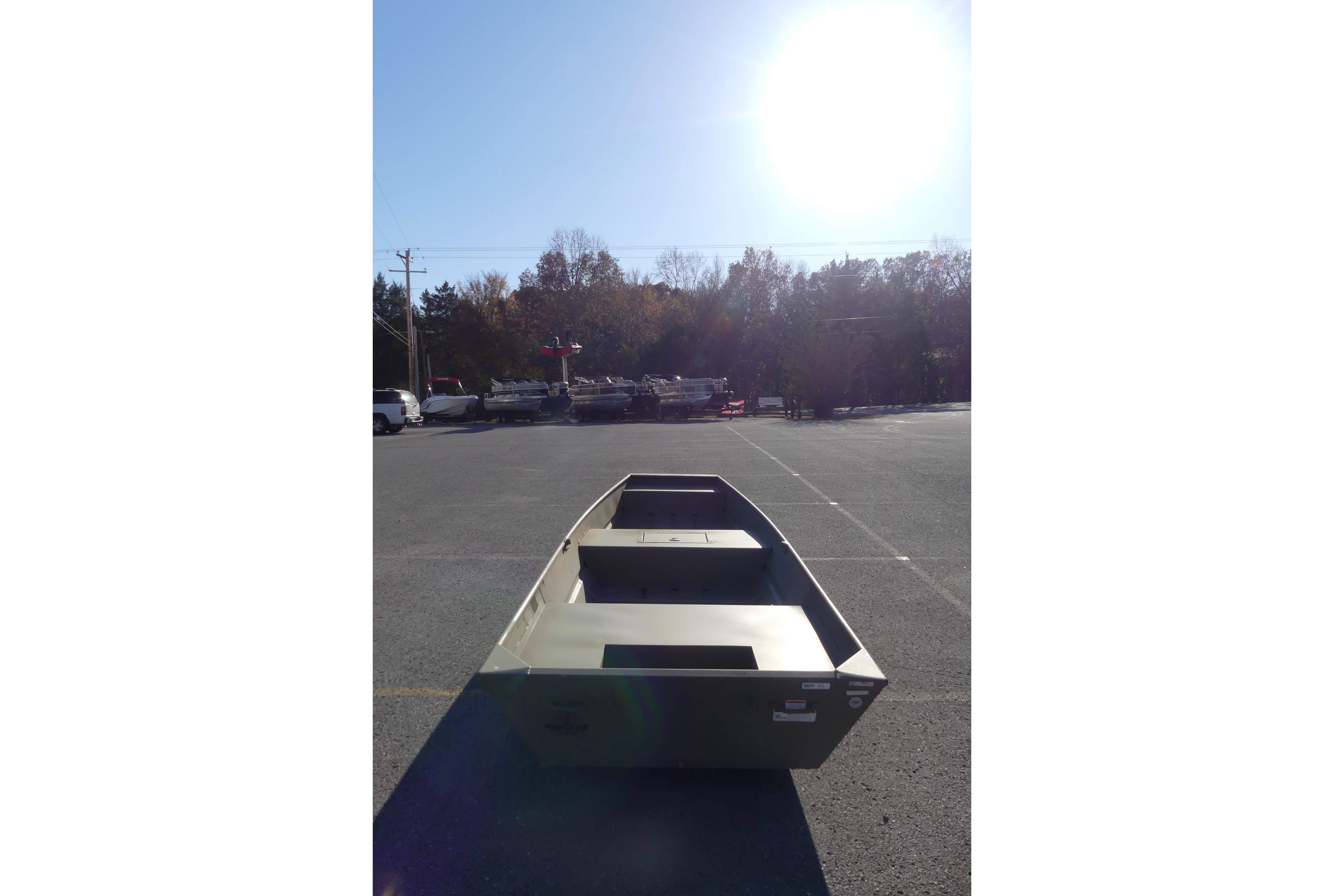 2026 Tracker Grizzly 15 Jon boat in a sunlit parking lot.