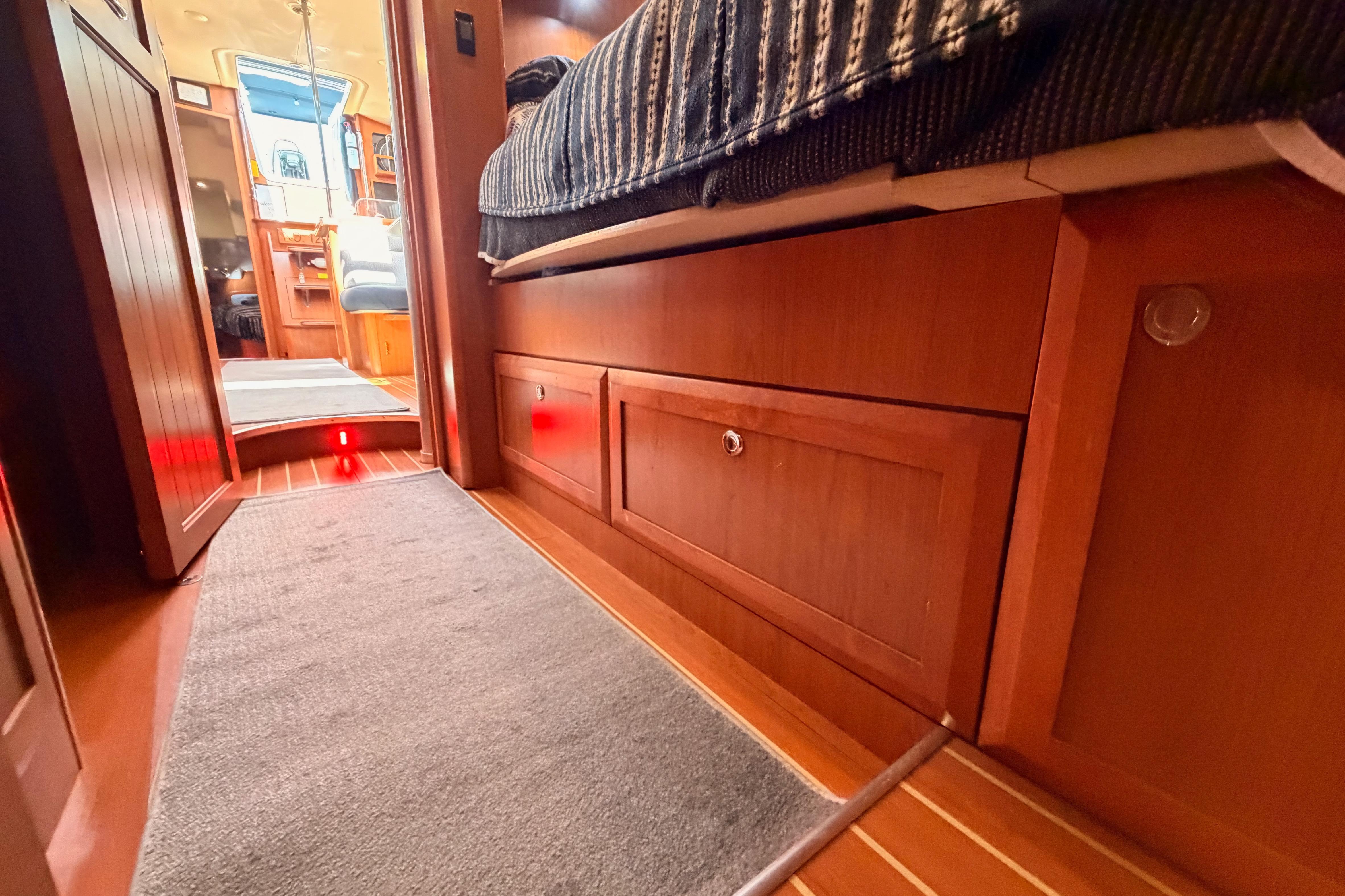 Interior of 2008 Hunter 45 Deck Salon yacht with wood cabinetry and cozy bedding.
