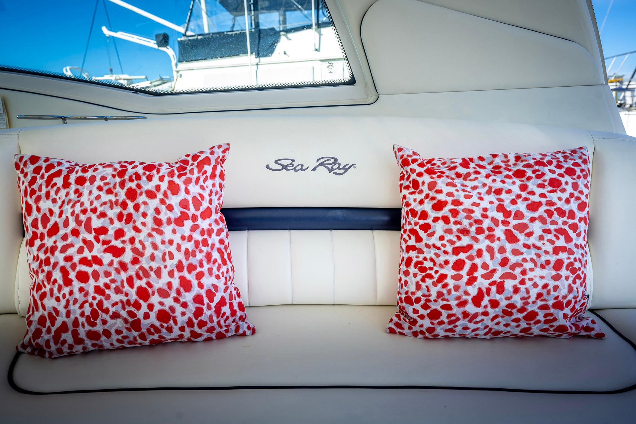 Interior of 2005 Sea Ray 500 Sundancer with red-patterned cushions on white seating.